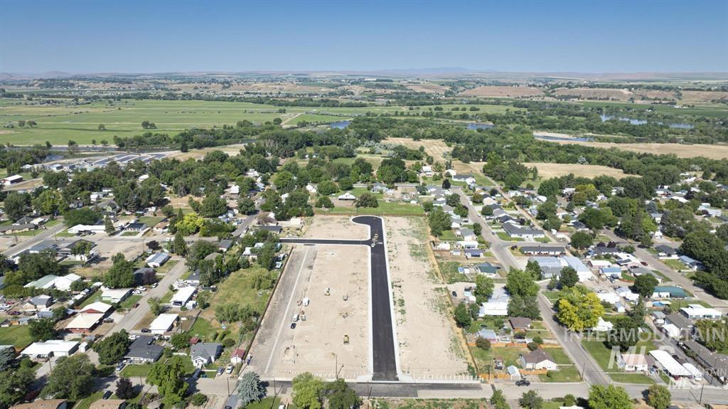 Aerial view of property and surrounding area featuring nearby suburban area
