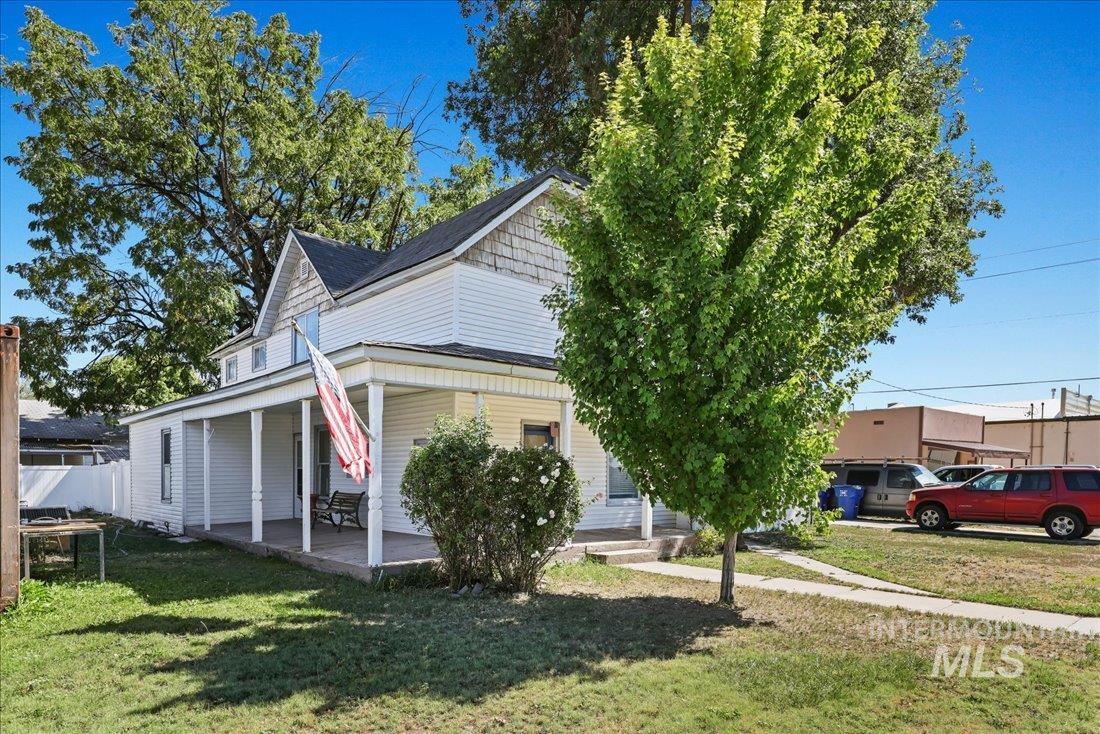View of front of property with covered porch and a front yard