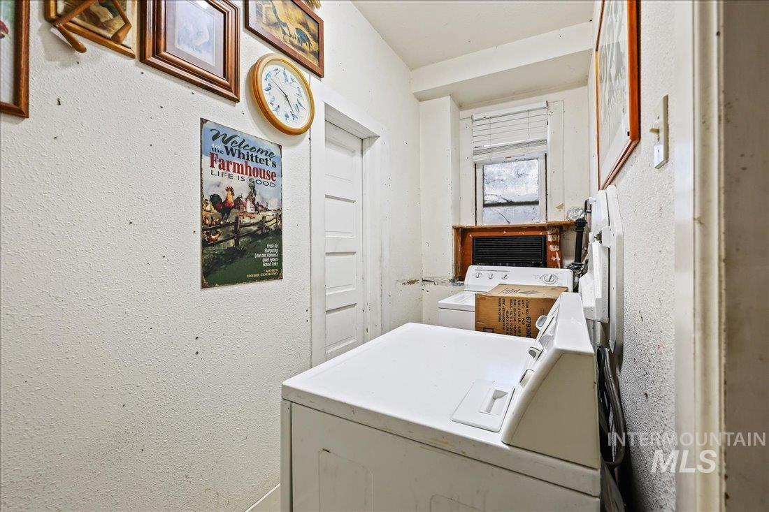 Washroom featuring washing machine and dryer and a textured wall