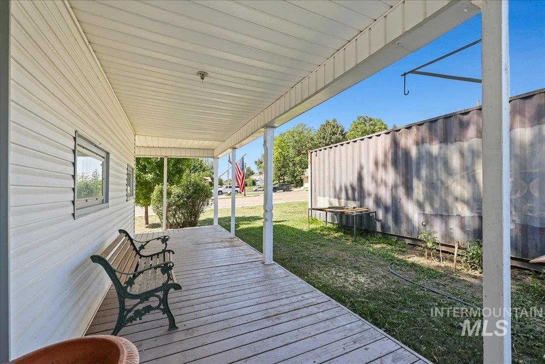 Wooden porch featuring a lawn
