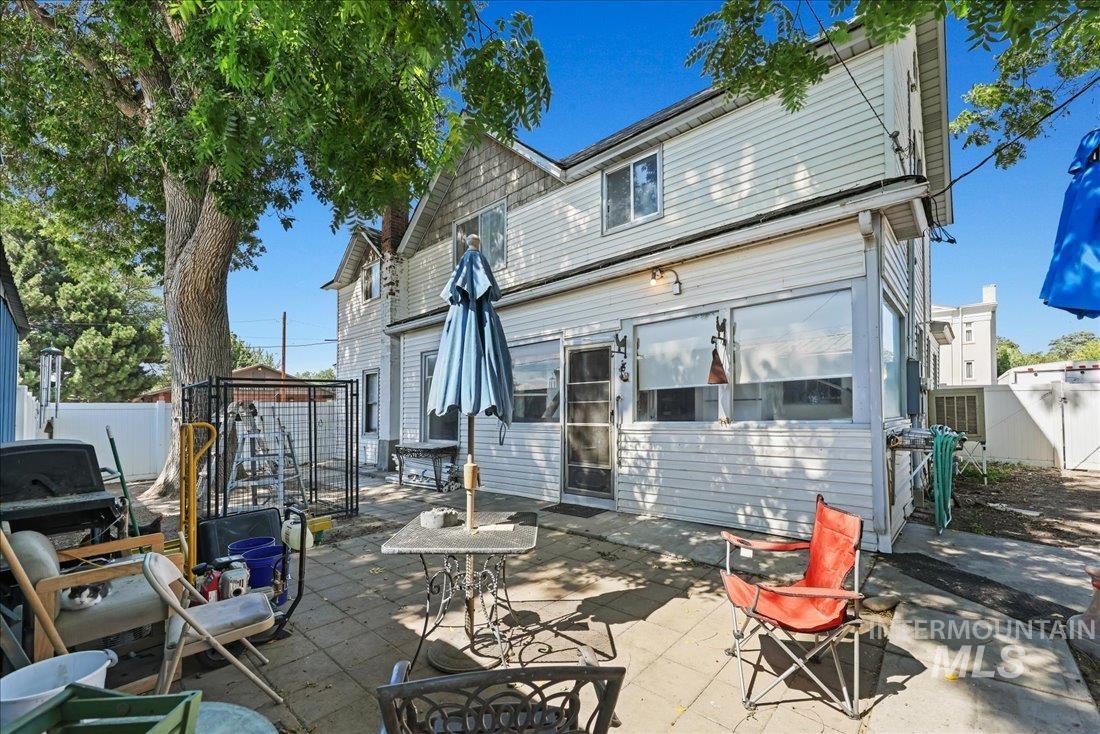 Rear view of house featuring a fenced backyard, a patio, and a gate