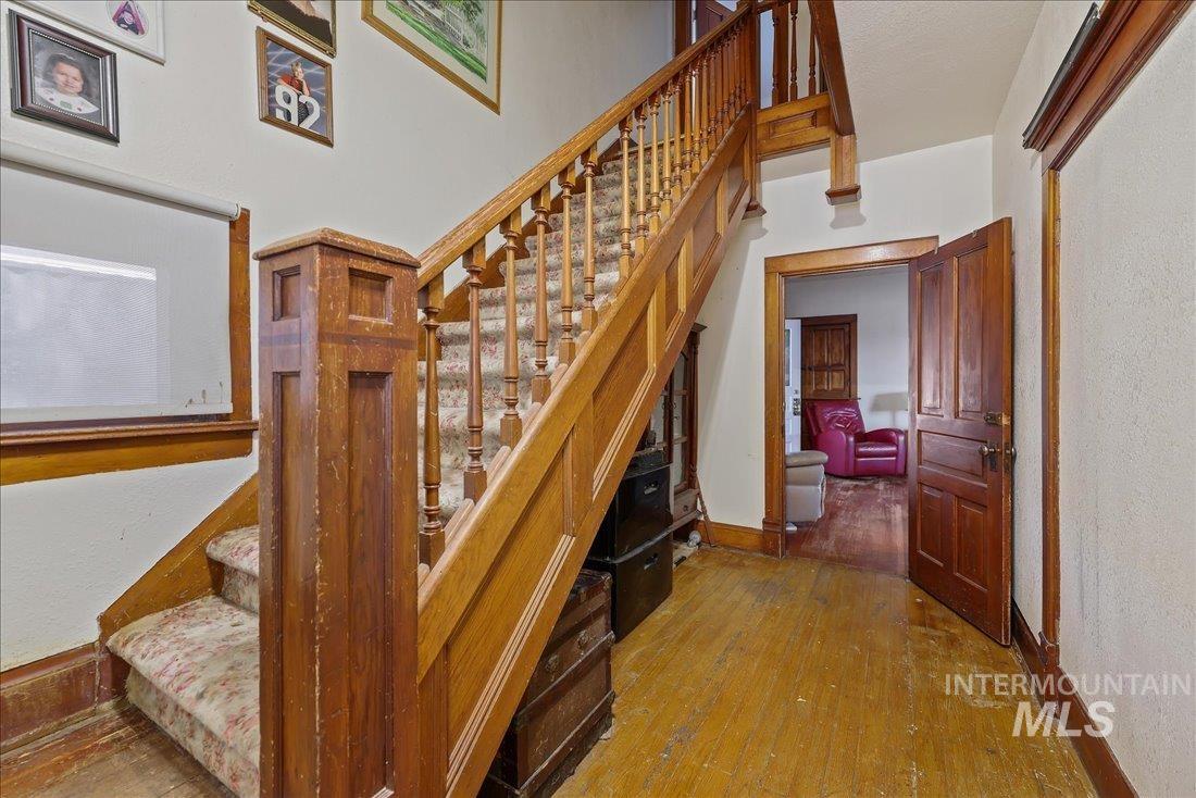 Stairway with hardwood / wood-style flooring and a textured wall