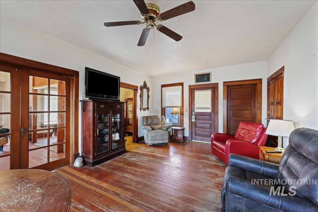 Living room featuring hardwood / wood-style floors, french doors, plenty of natural light, and a ceiling fan