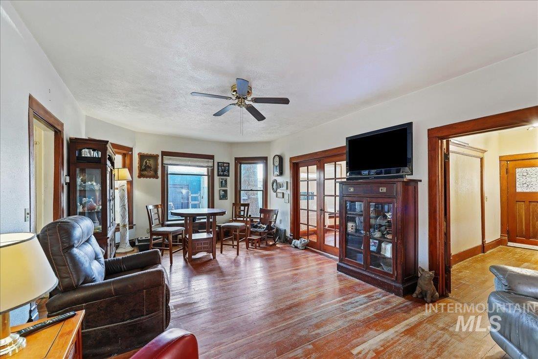 Living room with hardwood / wood-style floors, a ceiling fan, and a textured ceiling