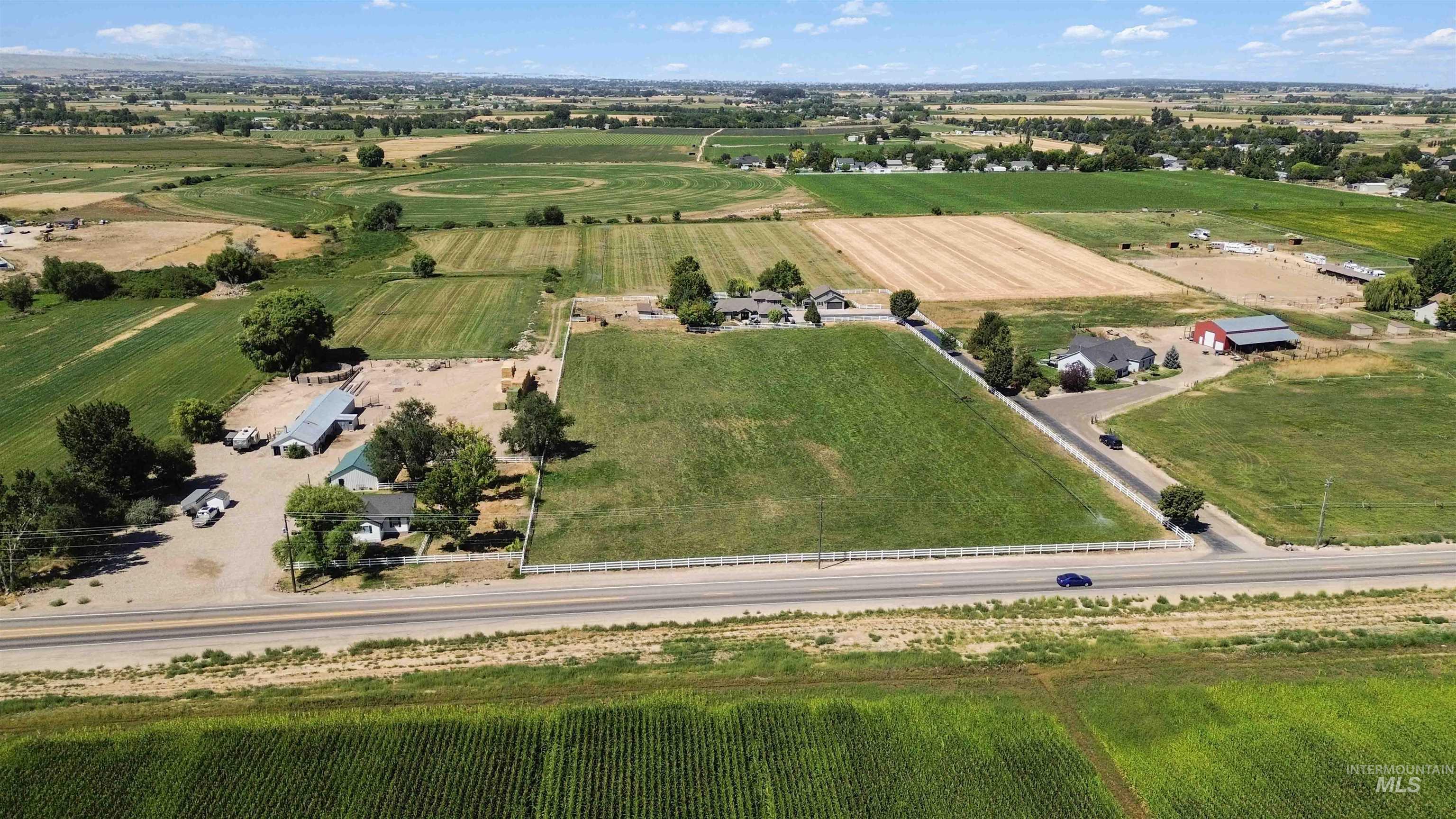 Aerial view of property and surrounding area featuring rural landscape and large plots for crops