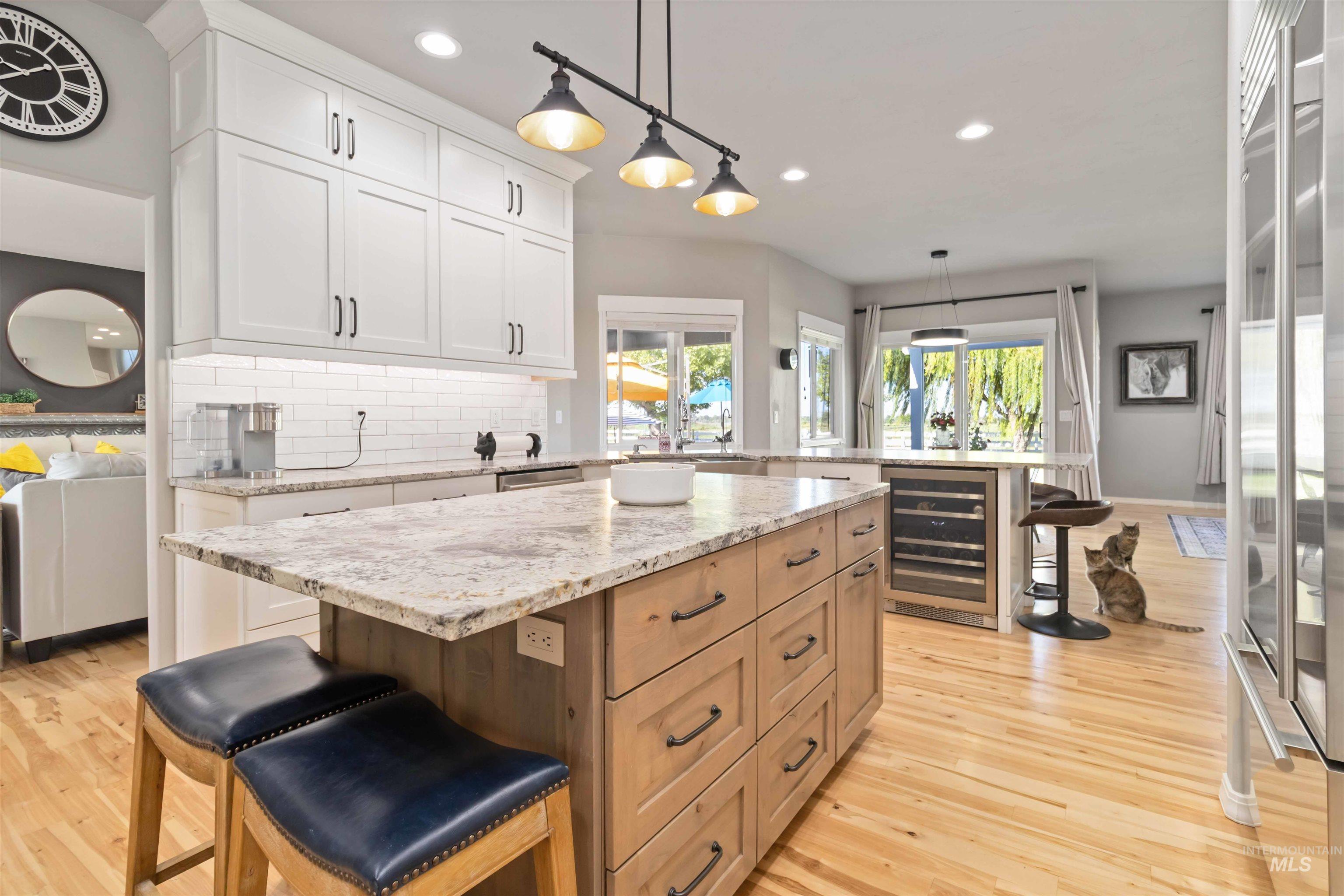 Kitchen with a kitchen bar, a kitchen island, tasteful backsplash, beverage cooler, and recessed lighting