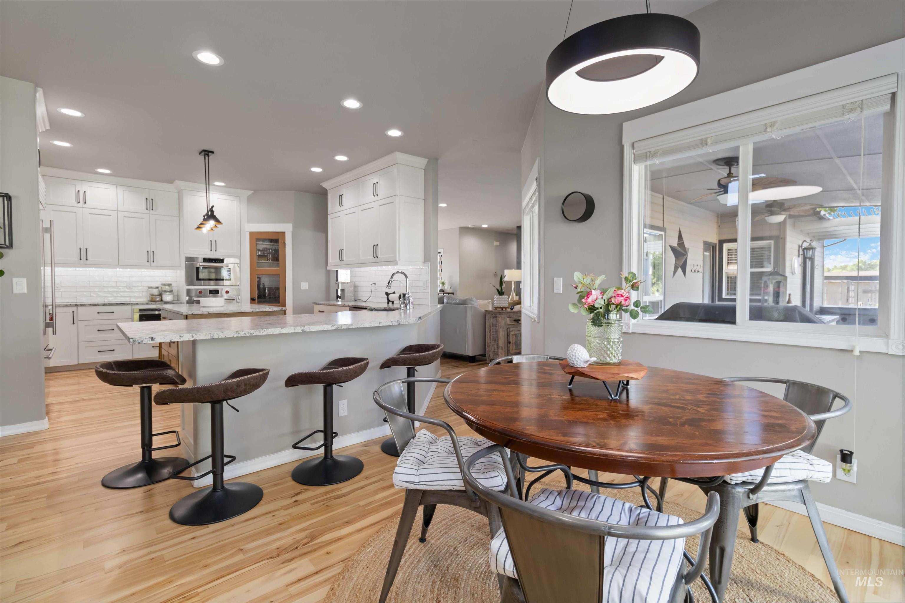 Dining space featuring light wood-style floors, a ceiling fan, and recessed lighting