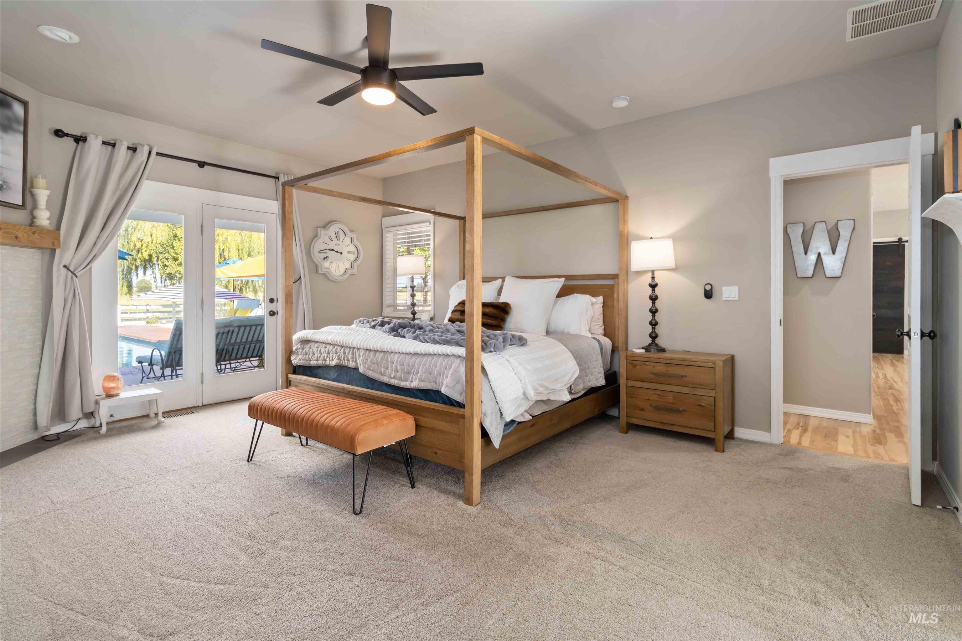 Bedroom with light carpet, ceiling fan, and access to outside