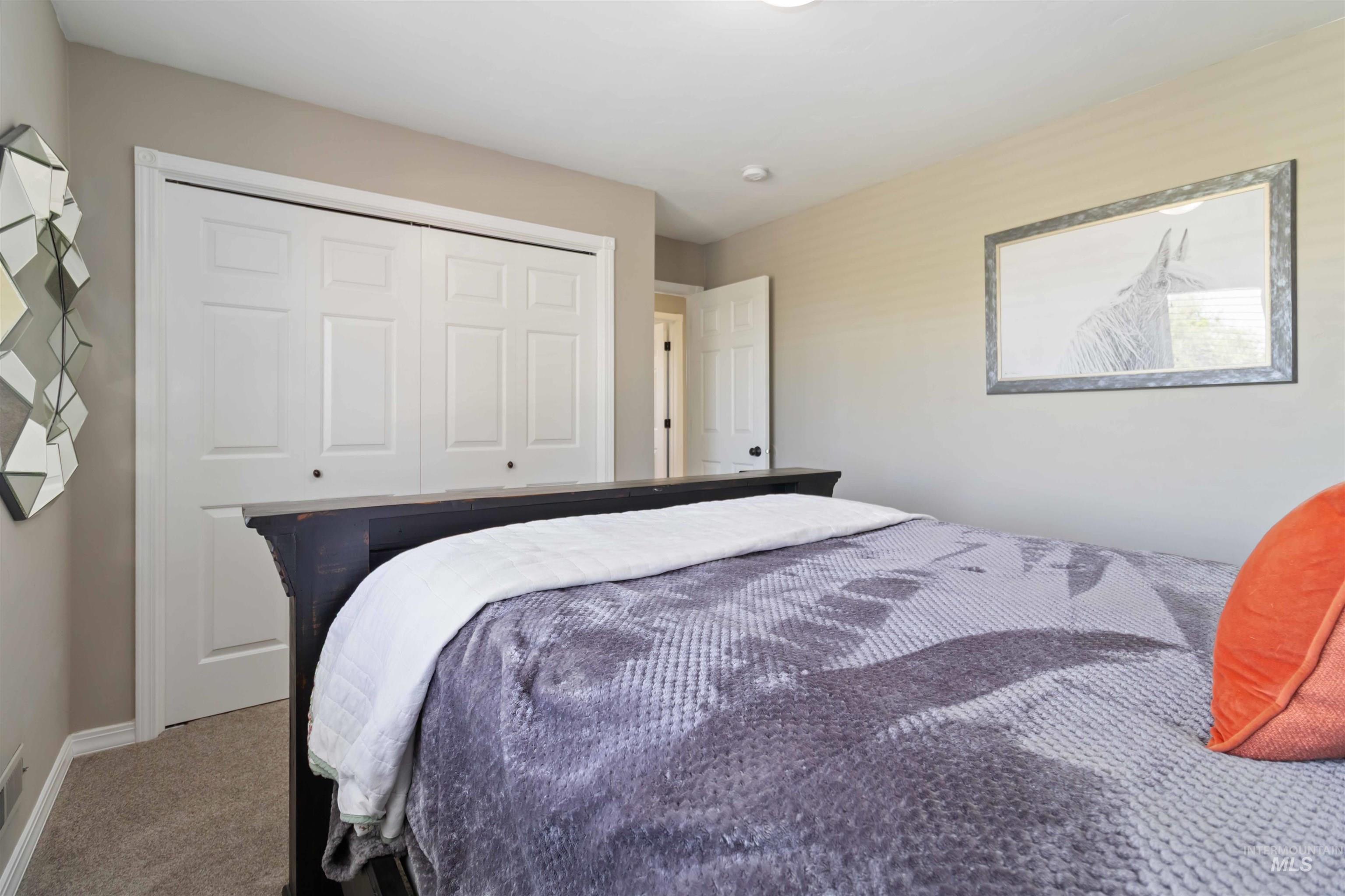 Carpeted bedroom with a closet and baseboards