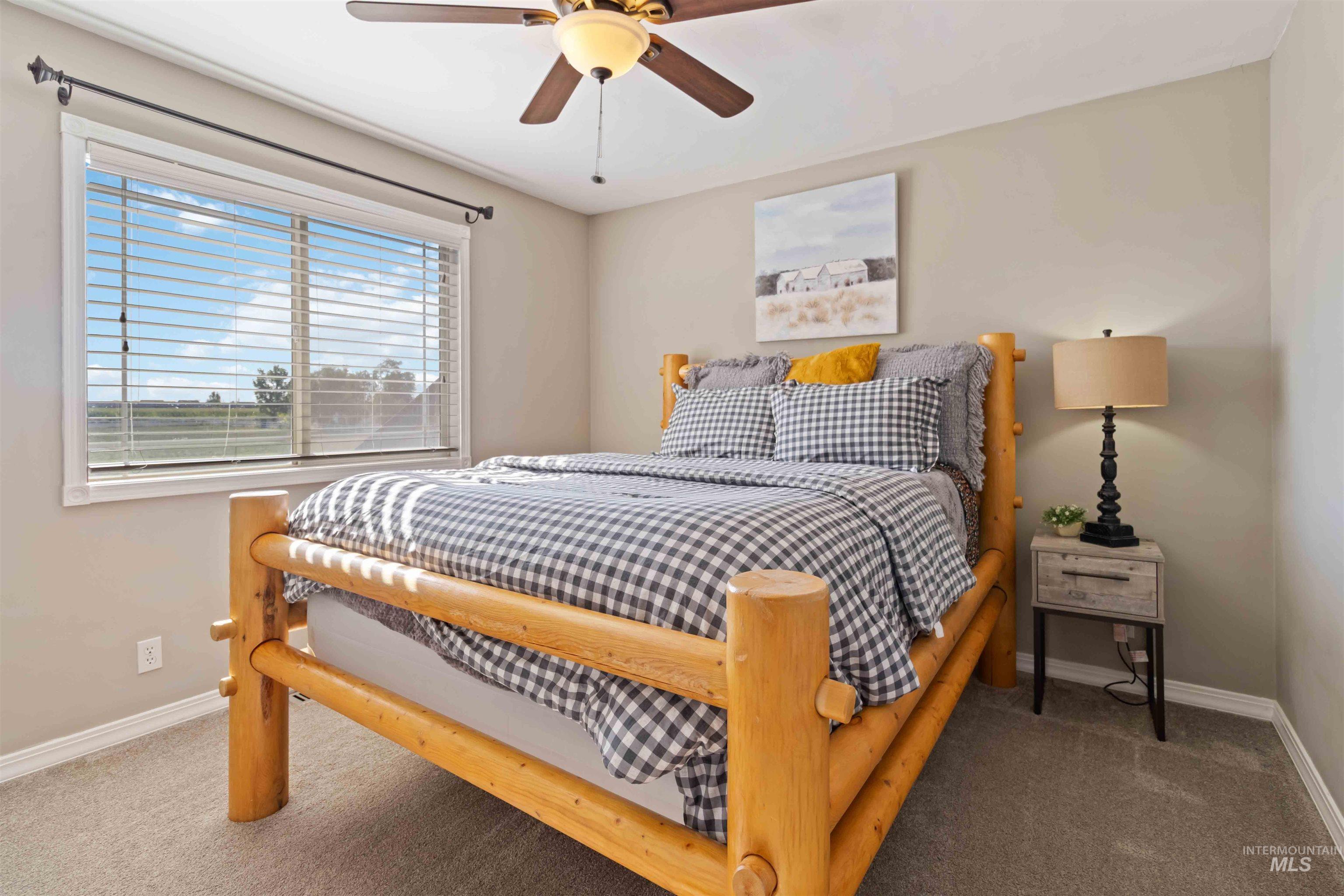 Carpeted bedroom featuring baseboards and ceiling fan