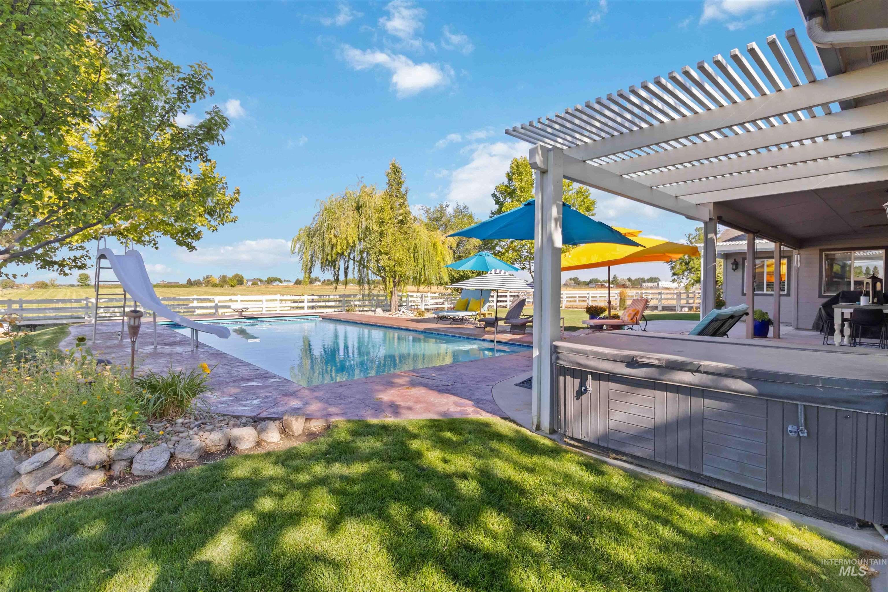 View of swimming pool with a pergola, a patio, a water slide, and a hot tub