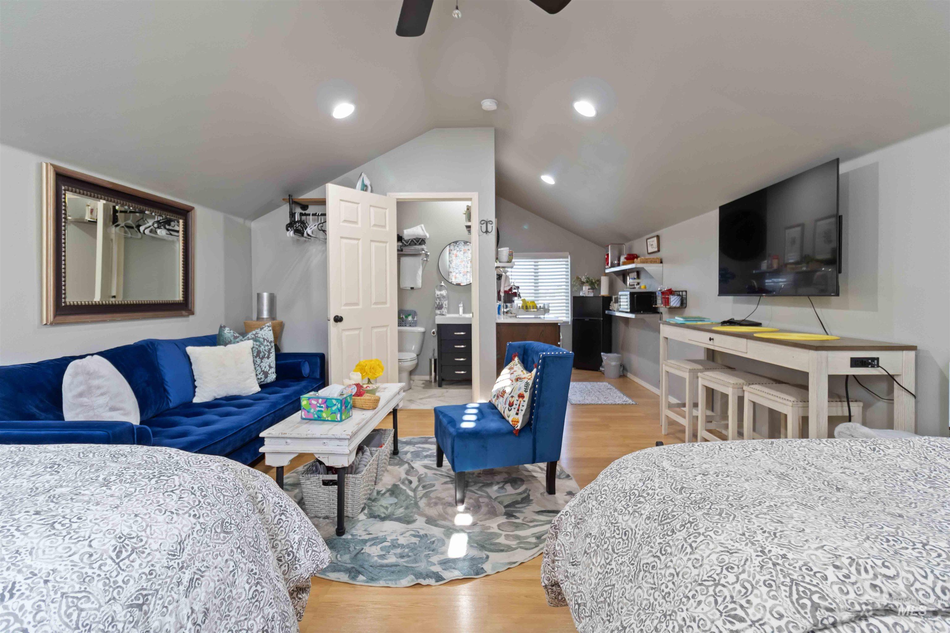 Living area with light wood-type flooring, recessed lighting, lofted ceiling, and ceiling fan