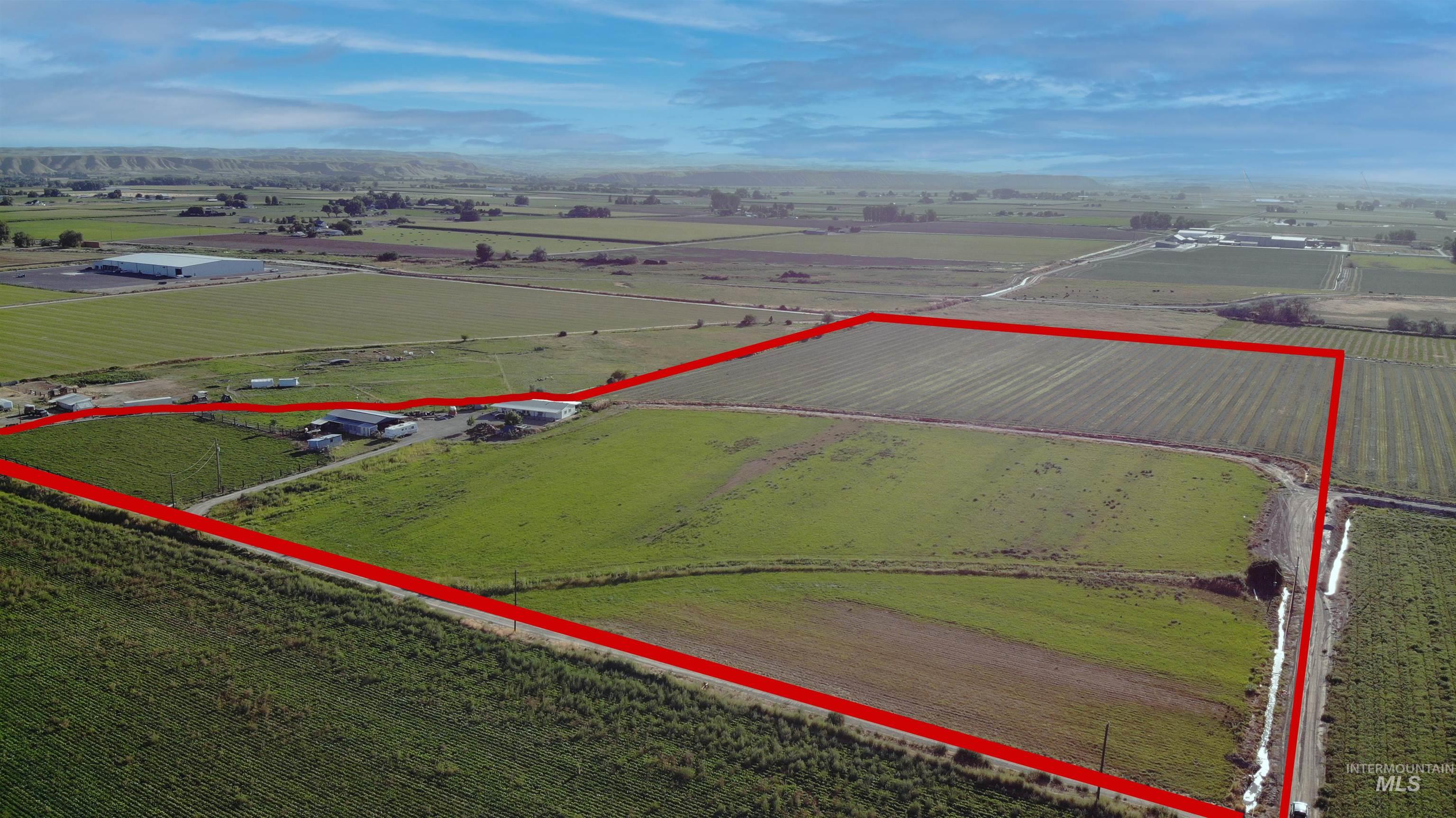 Aerial view of sparsely populated area featuring property boundaries highlighted and rows of crops