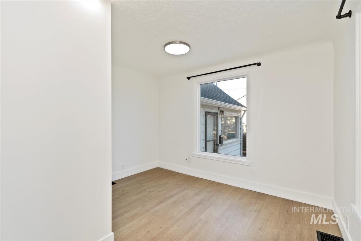Empty room with light wood finished floors and baseboards