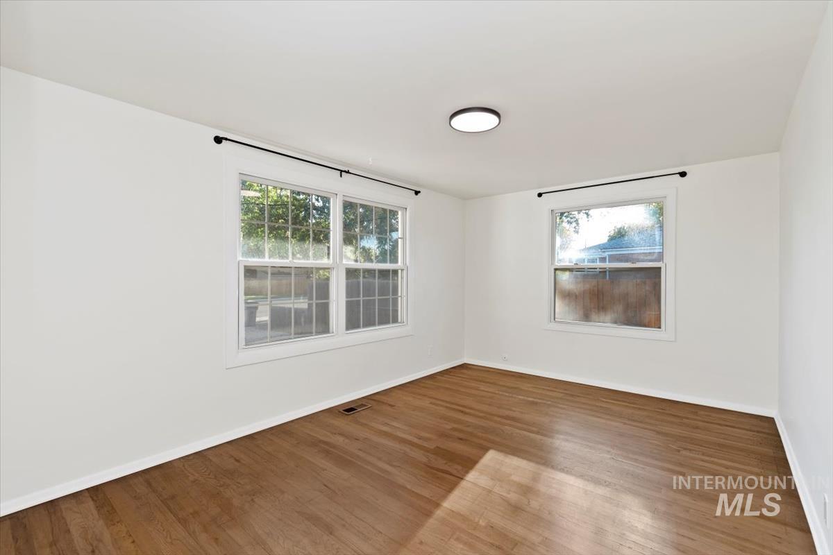 Unfurnished room with wood finished floors and baseboards