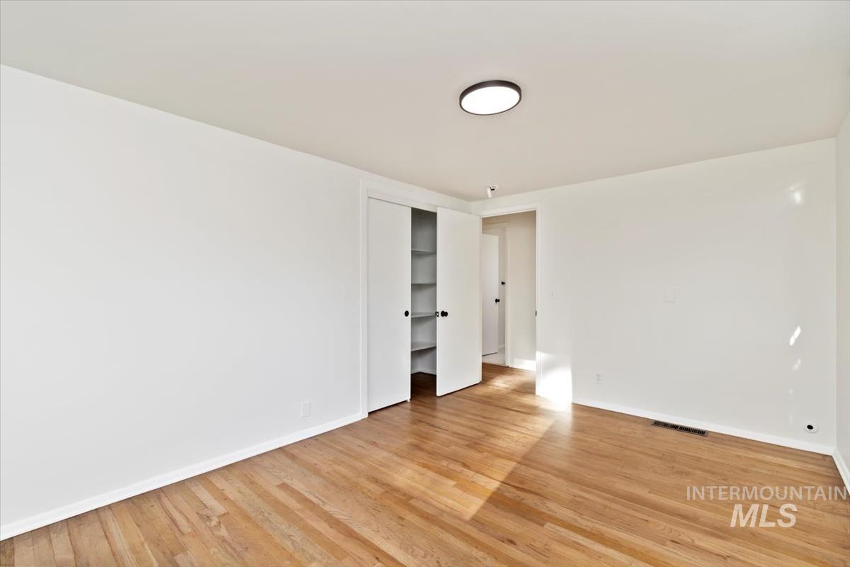 Unfurnished bedroom featuring light wood-style floors and a closet