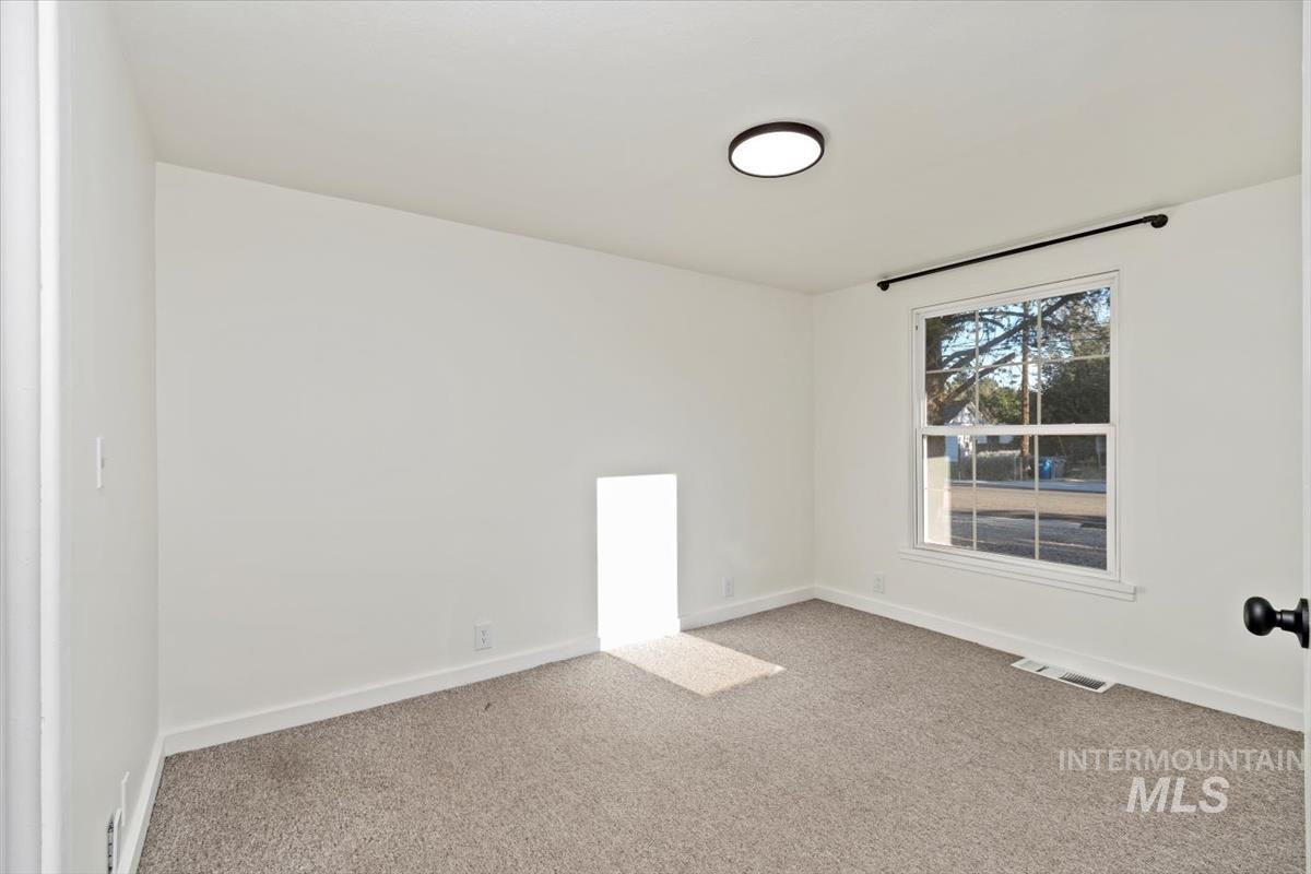 Carpeted spare room with baseboards