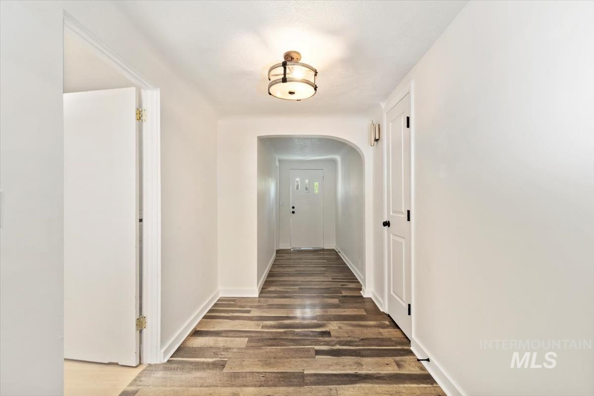 Corridor with wood finished floors and arched walkways