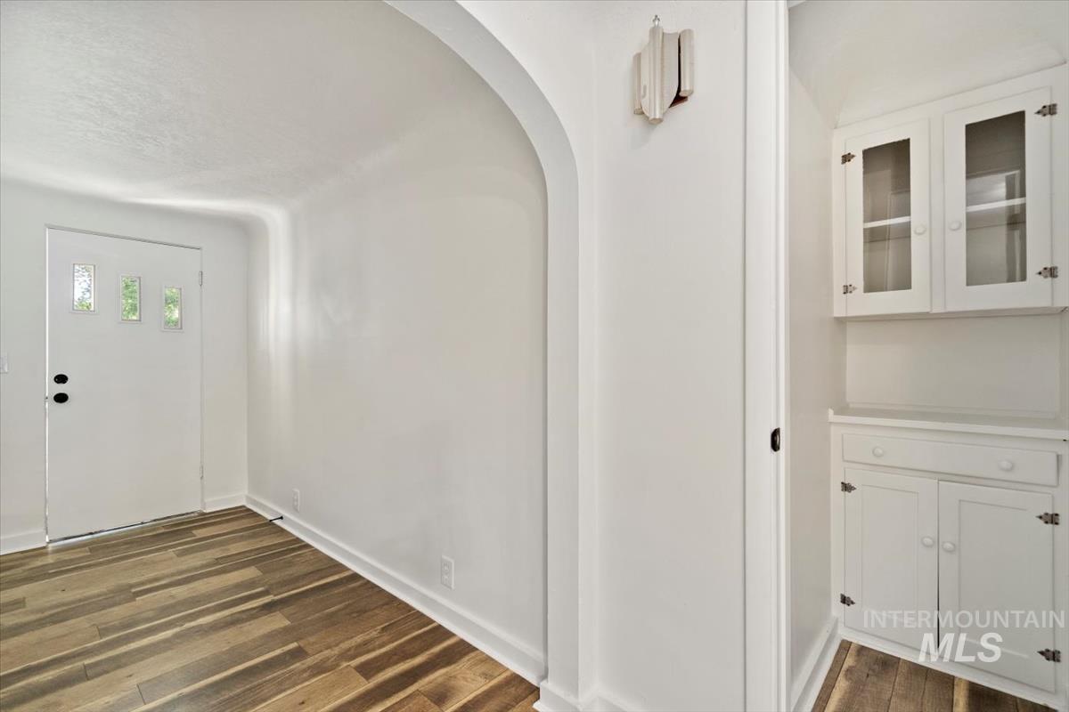 Entryway with dark wood finished floors and arched walkways
