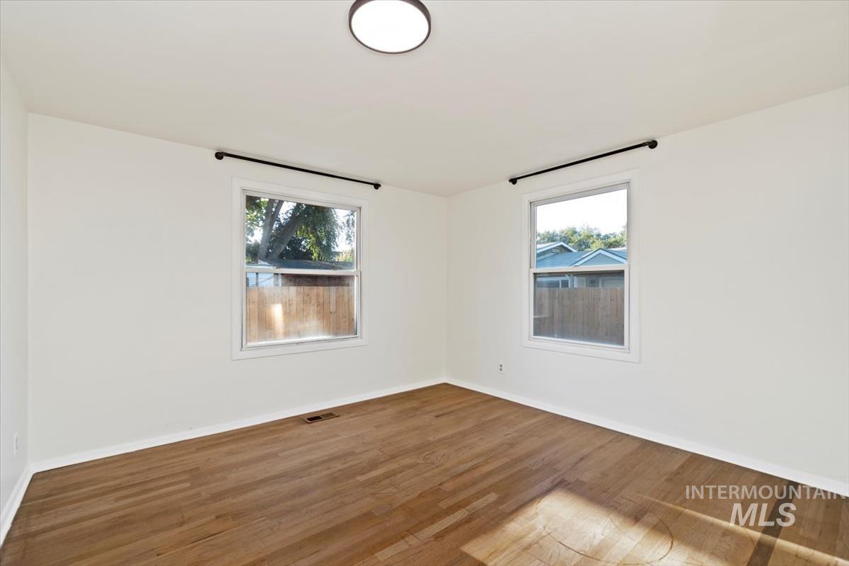 Empty room featuring wood finished floors and healthy amount of natural light