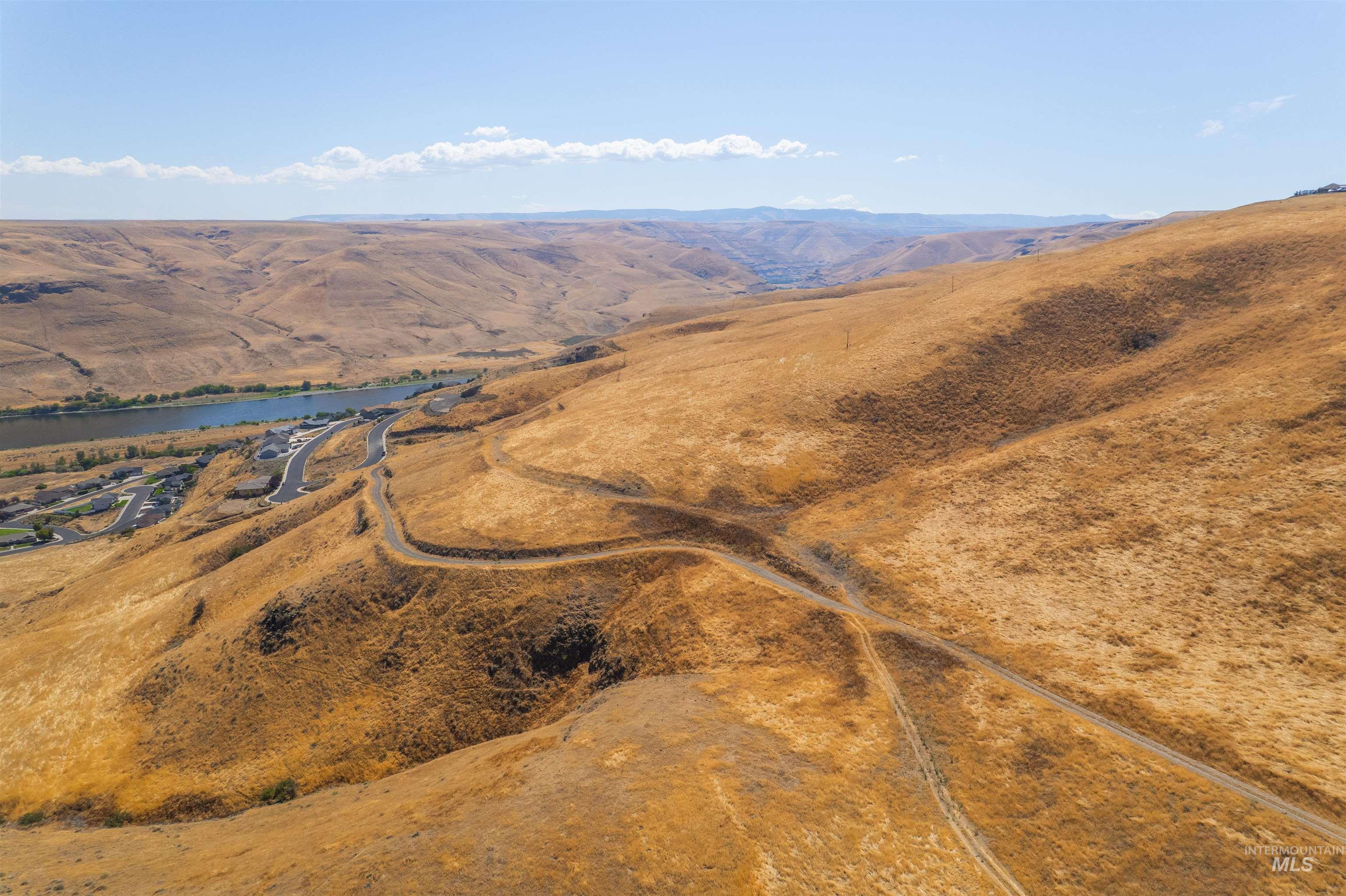 Aerial view of property and surrounding area featuring a water and mountain view and rural landscape