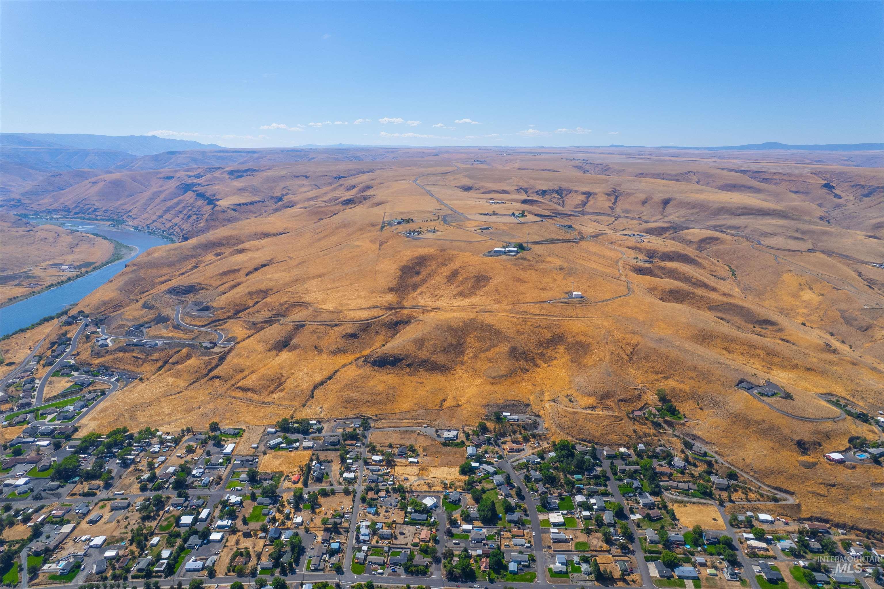 Aerial view of property and surrounding area with a mountain backdrop