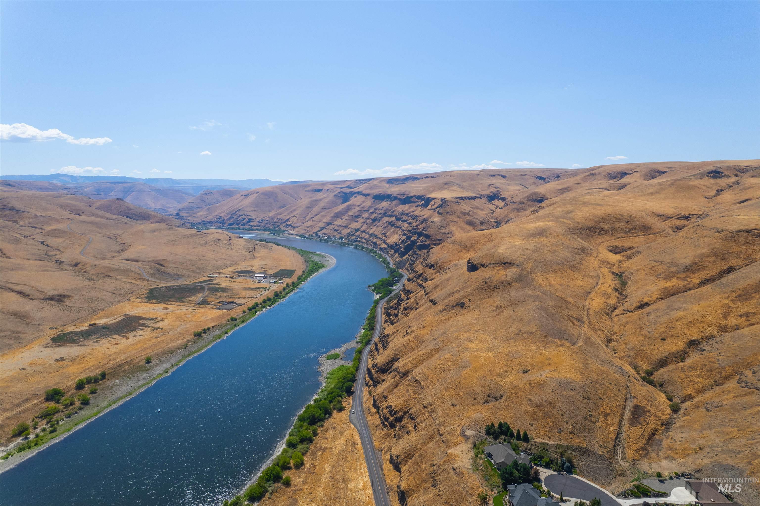 Aerial view of property and surrounding area featuring a water and mountain view