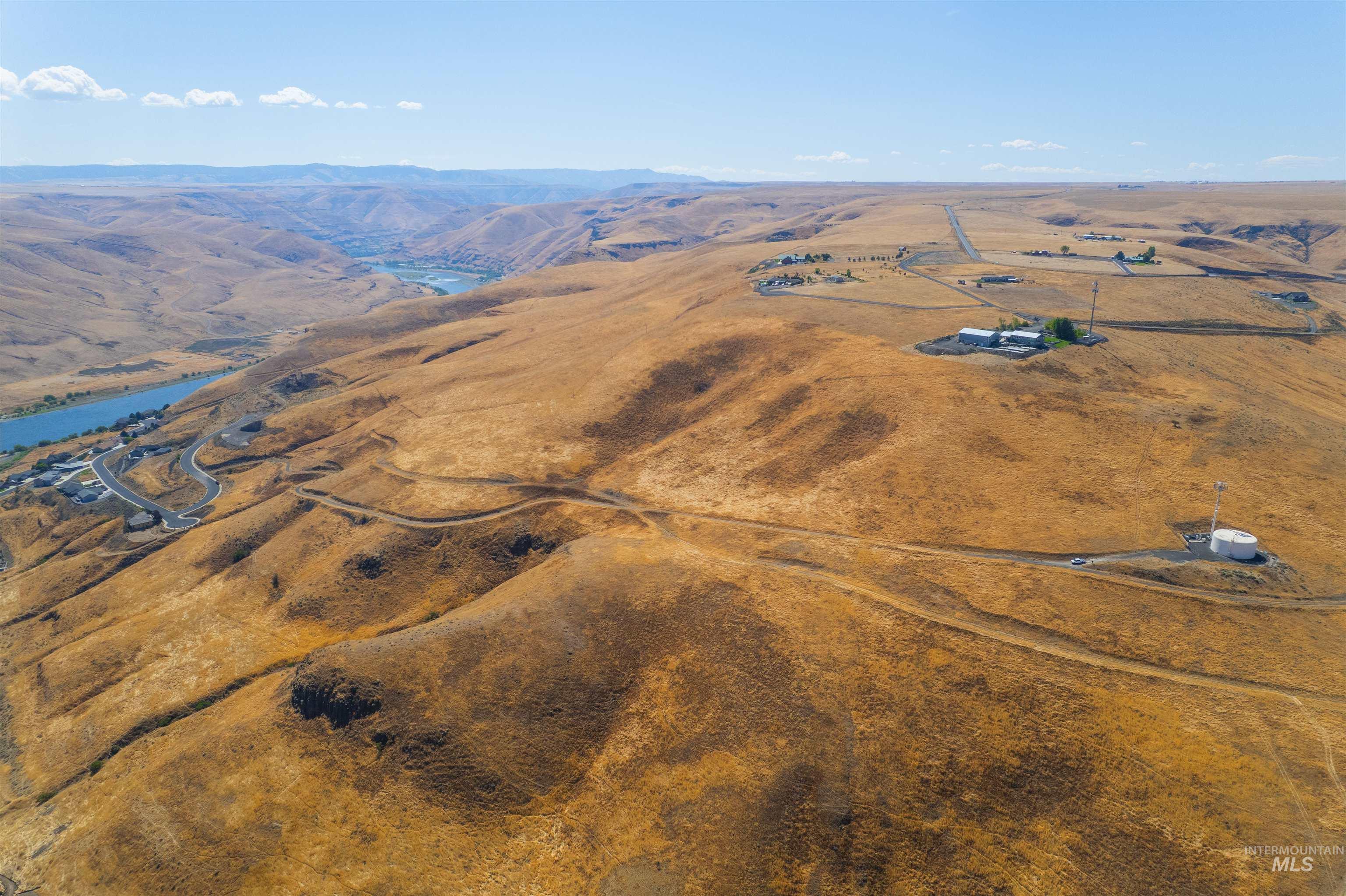 Aerial view of property and surrounding area with a mountain backdrop and rural landscape