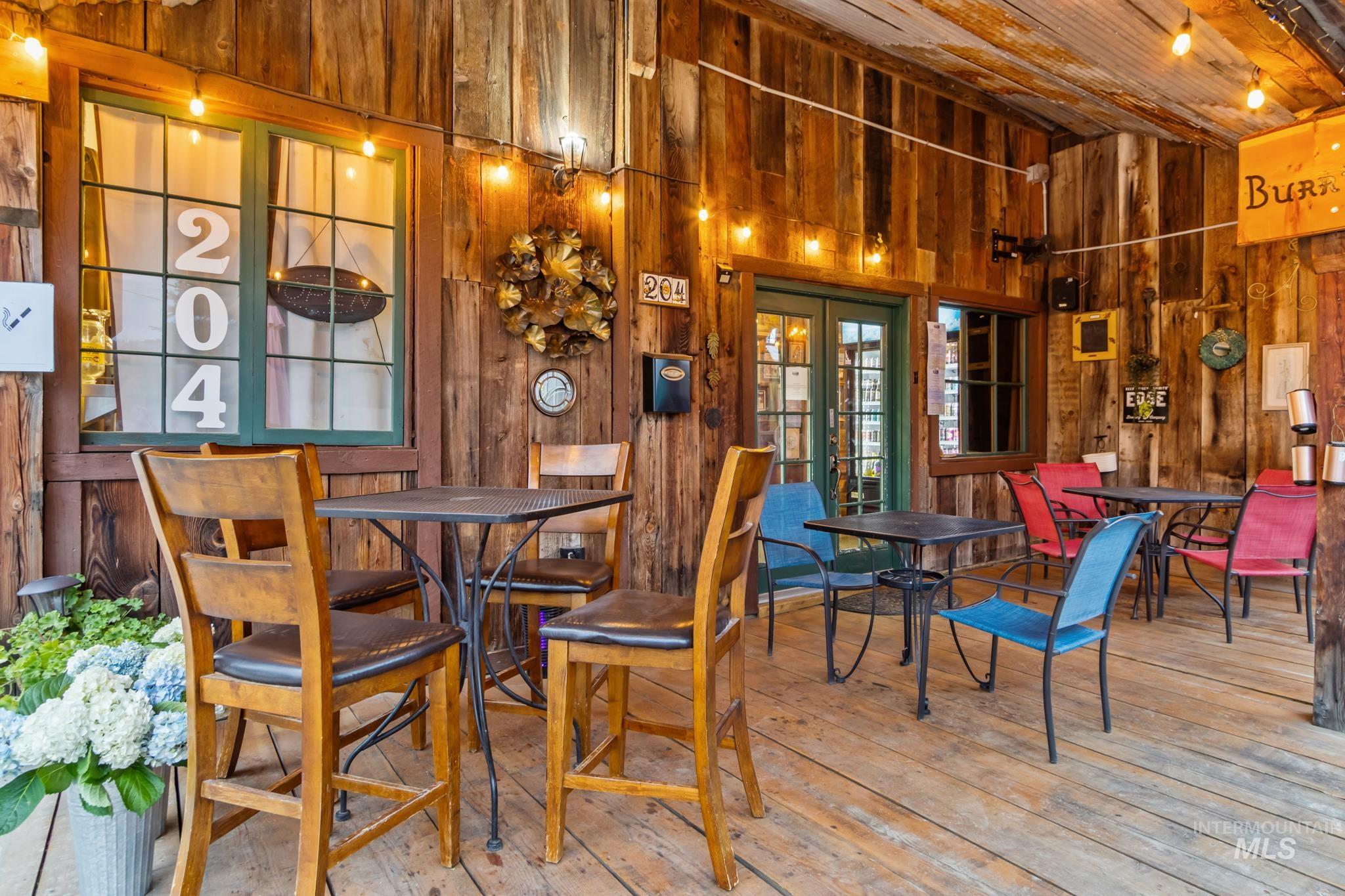 Dining space featuring wooden walls, hardwood / wood-style floors, french doors, wood ceiling, and a high ceiling