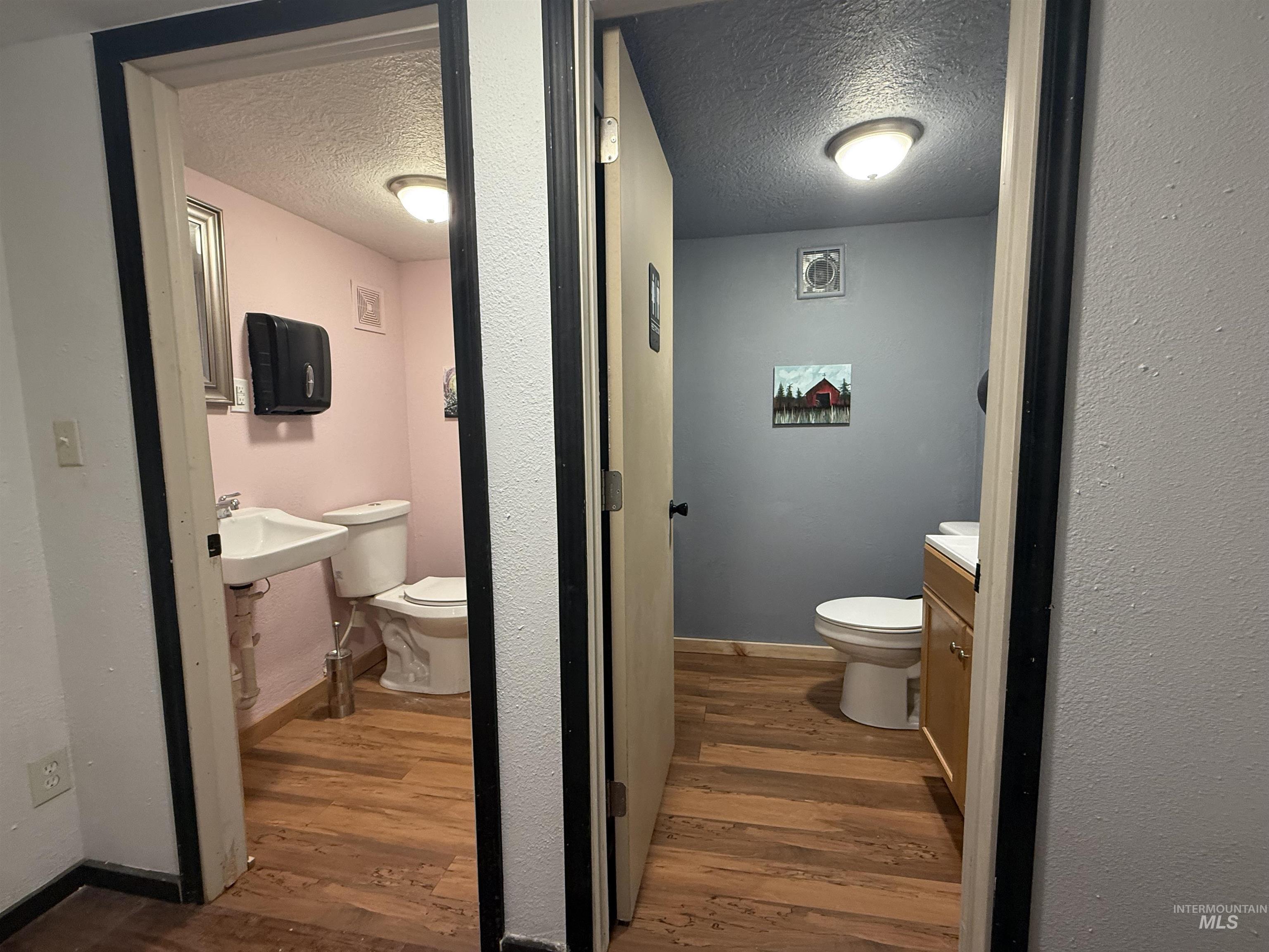 Bathroom featuring dark wood-style floors, a textured ceiling, and vanity