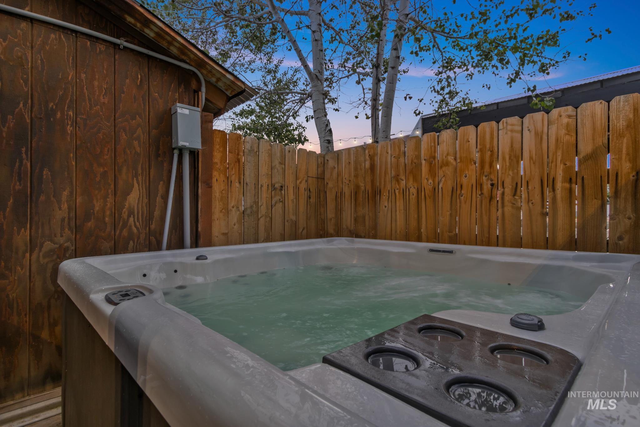 Yard at dusk featuring a hot tub