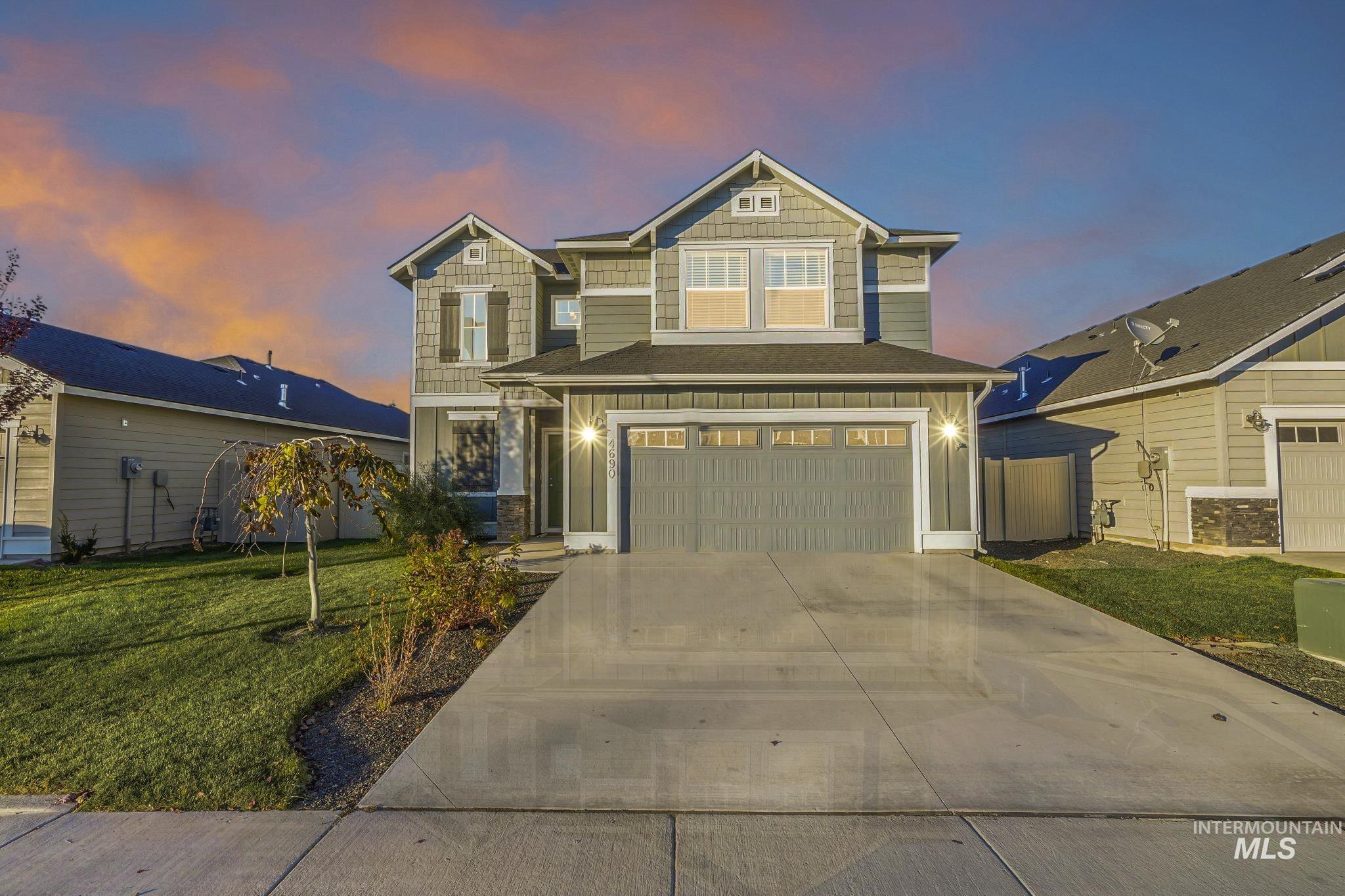 Craftsman-style home with a garage, concrete driveway, a yard, and board and batten siding