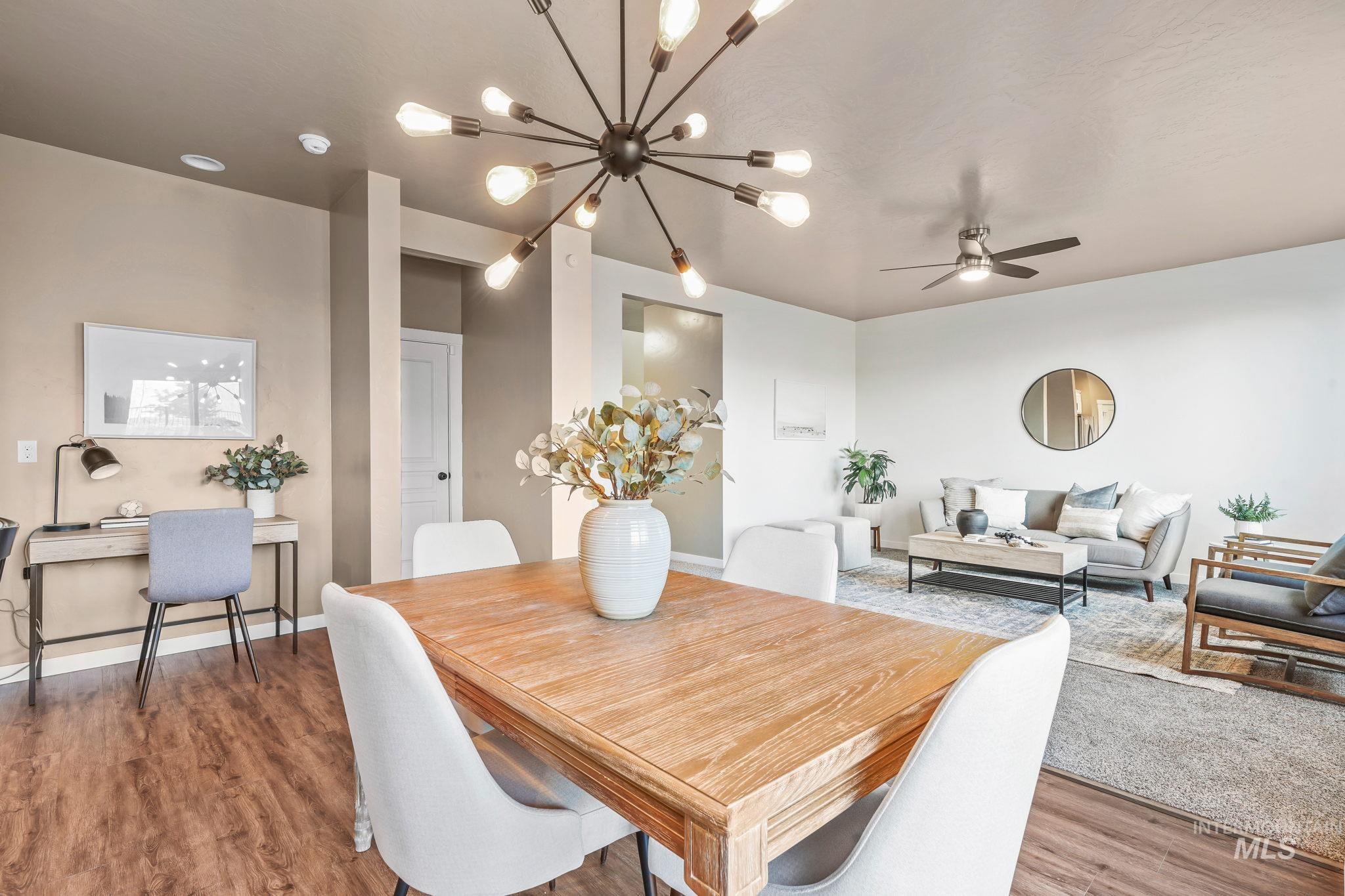 Dining space featuring wood finished floors, ceiling fan, and a chandelier