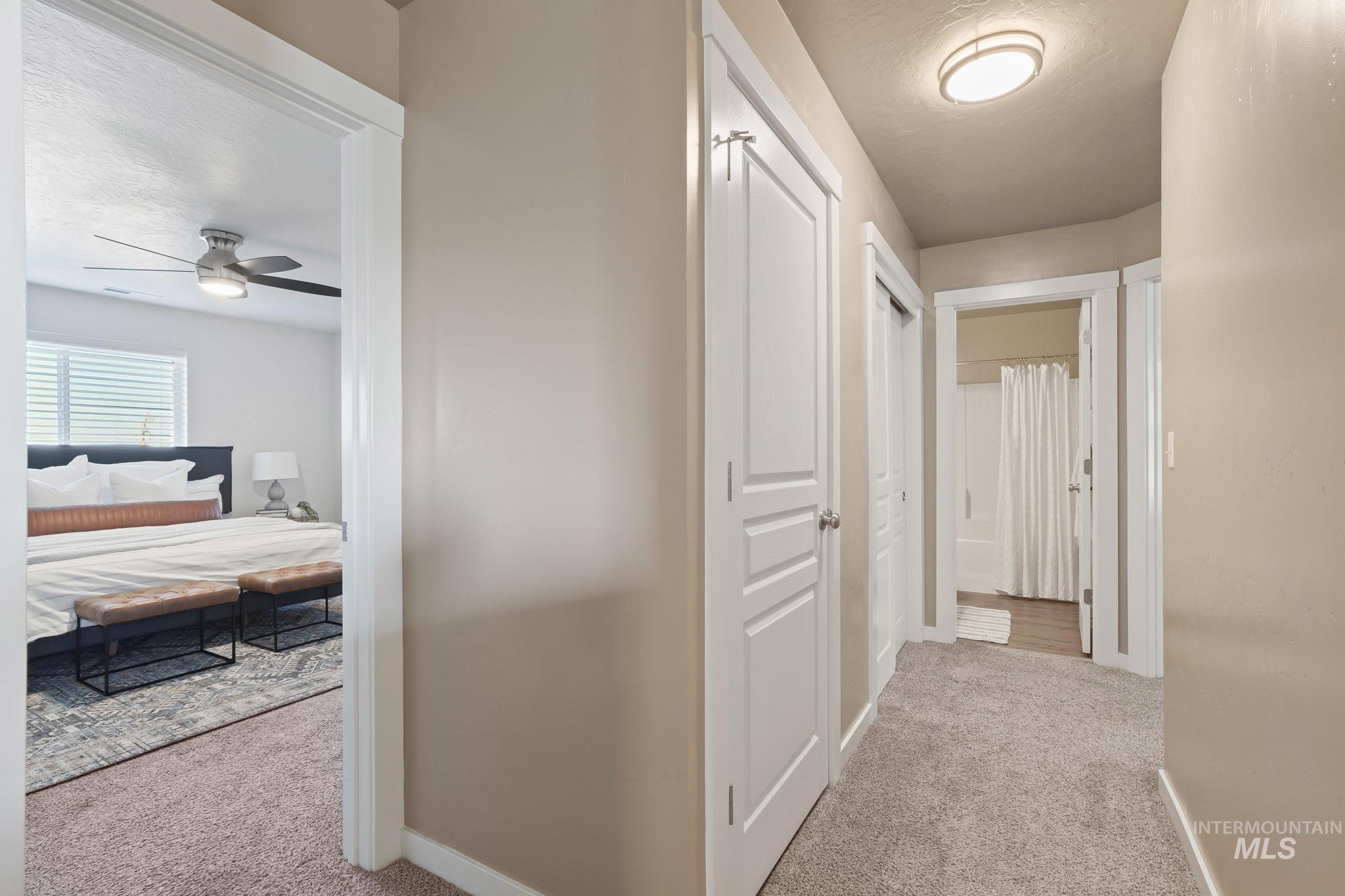 Corridor with light colored carpet and a textured ceiling