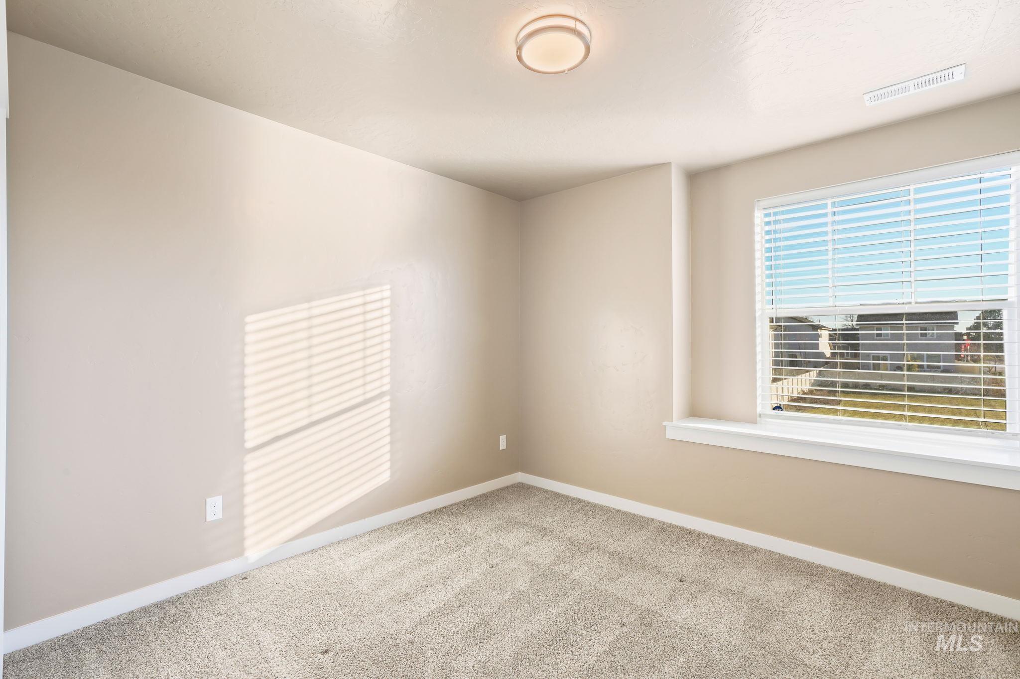Carpeted empty room with baseboards