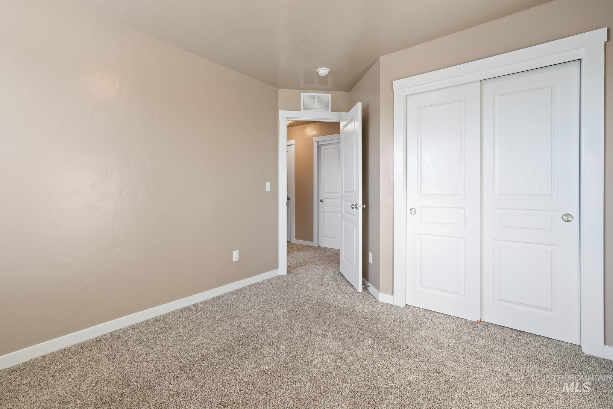 Unfurnished bedroom with light carpet and a closet