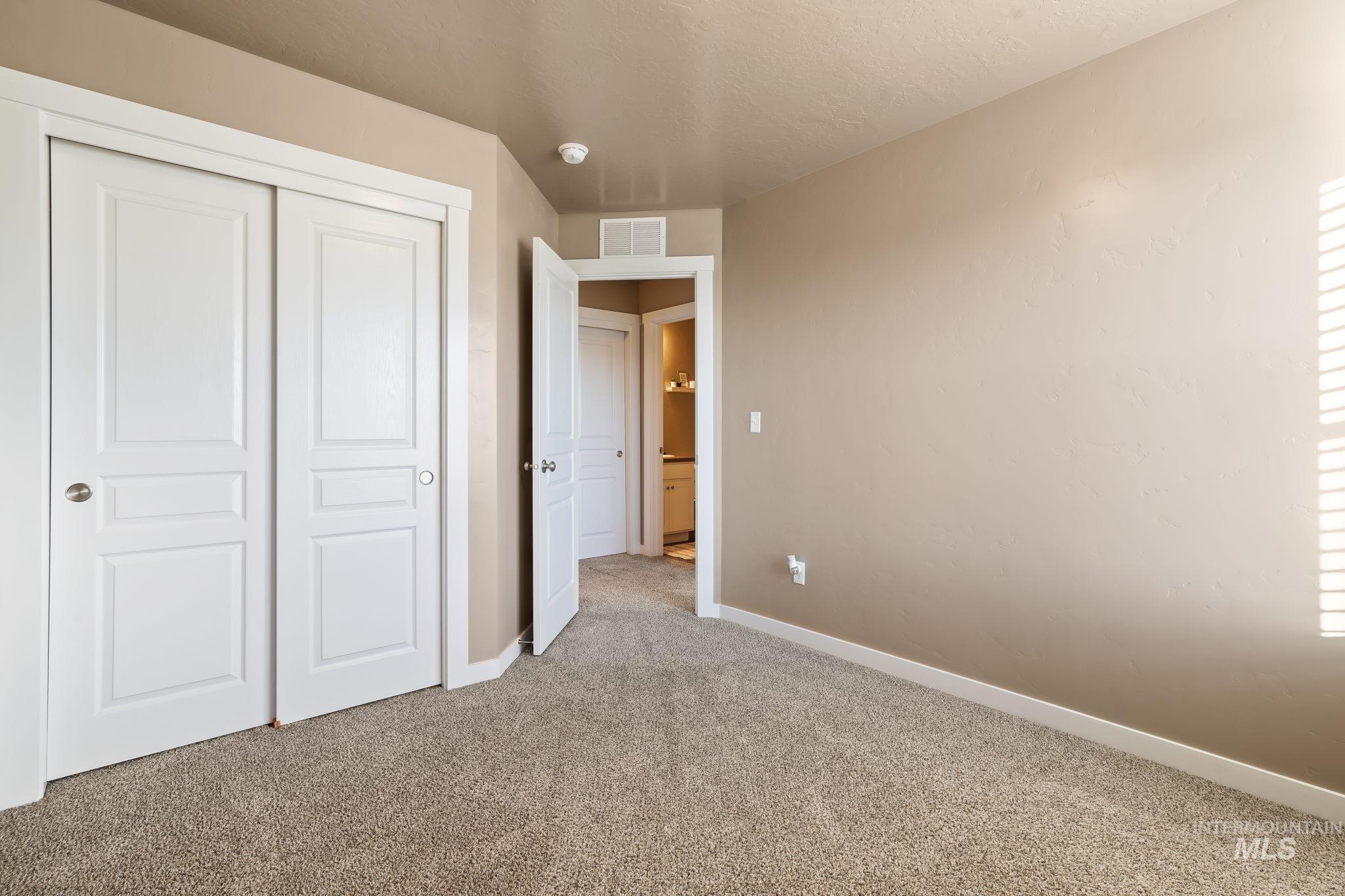Unfurnished bedroom featuring light carpet, a closet, and a textured ceiling