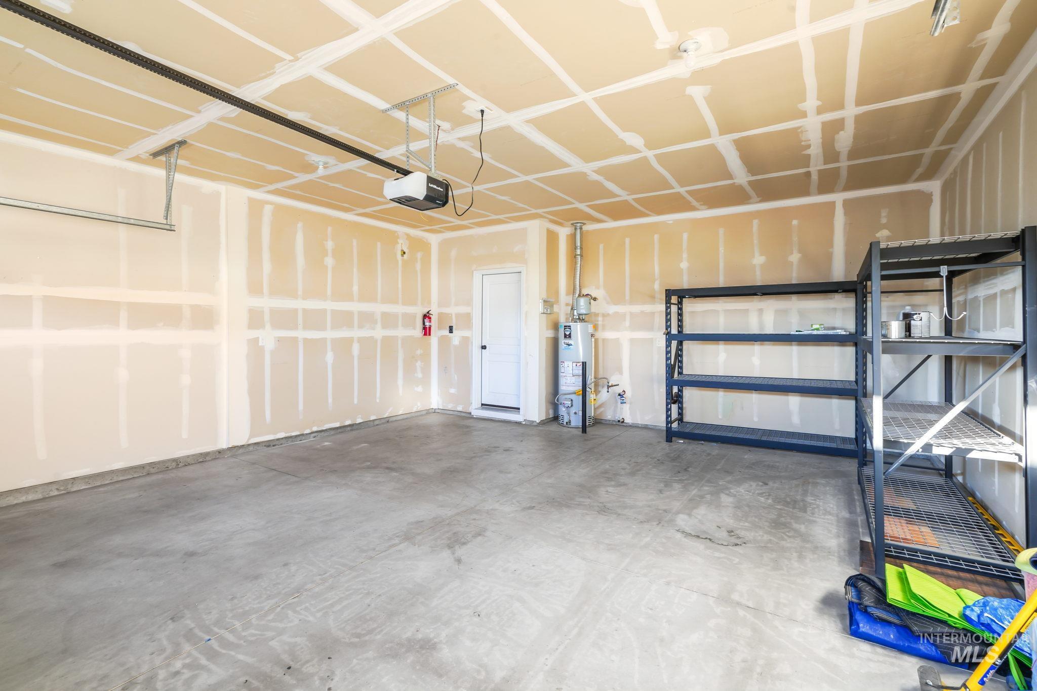 Garage with gas water heater and a garage door opener