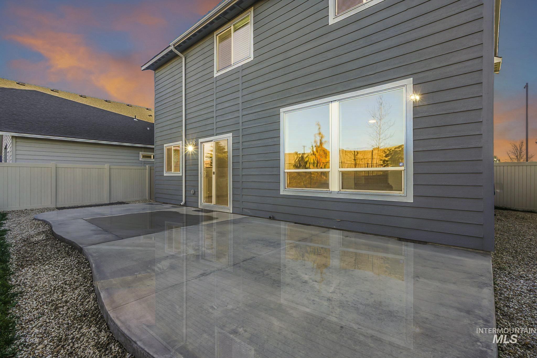 Back of property at dusk featuring a patio