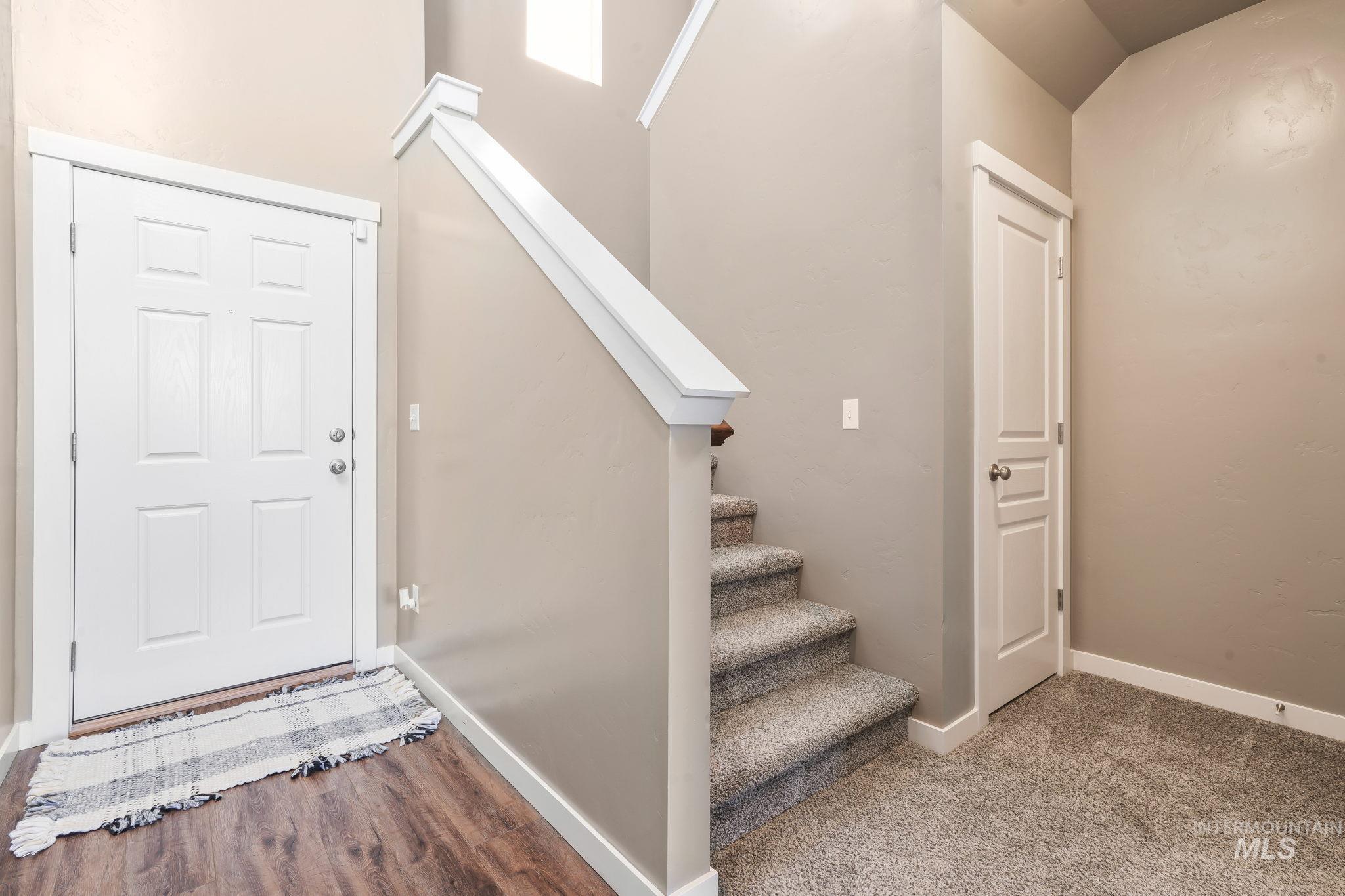 Entrance foyer with stairway and baseboards
