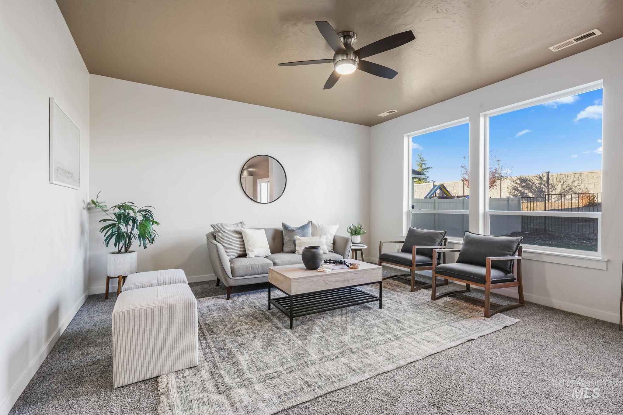 Living room featuring carpet flooring and a ceiling fan
