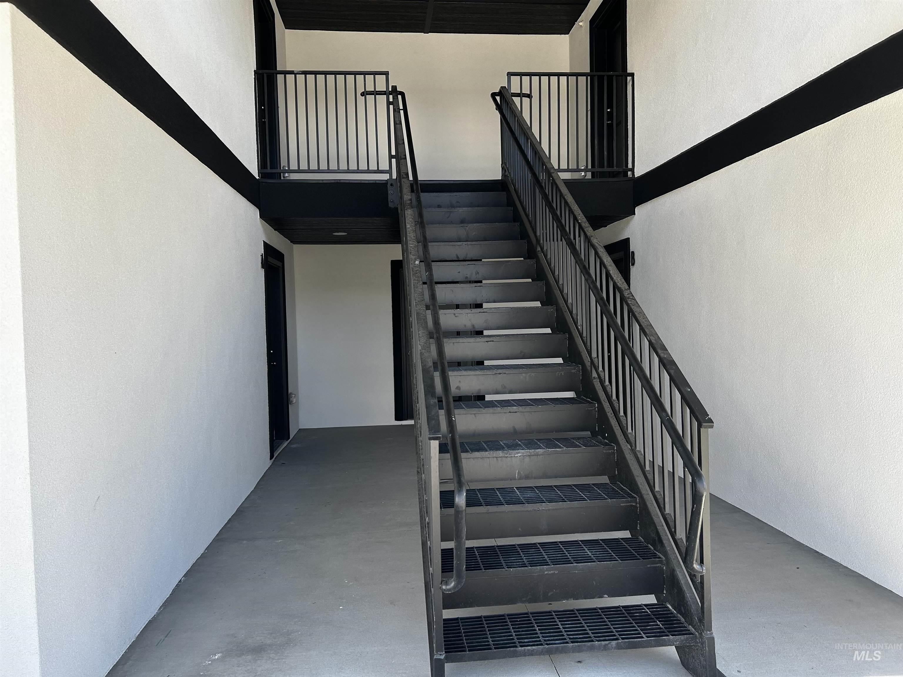 Stairway with a towering ceiling and concrete flooring