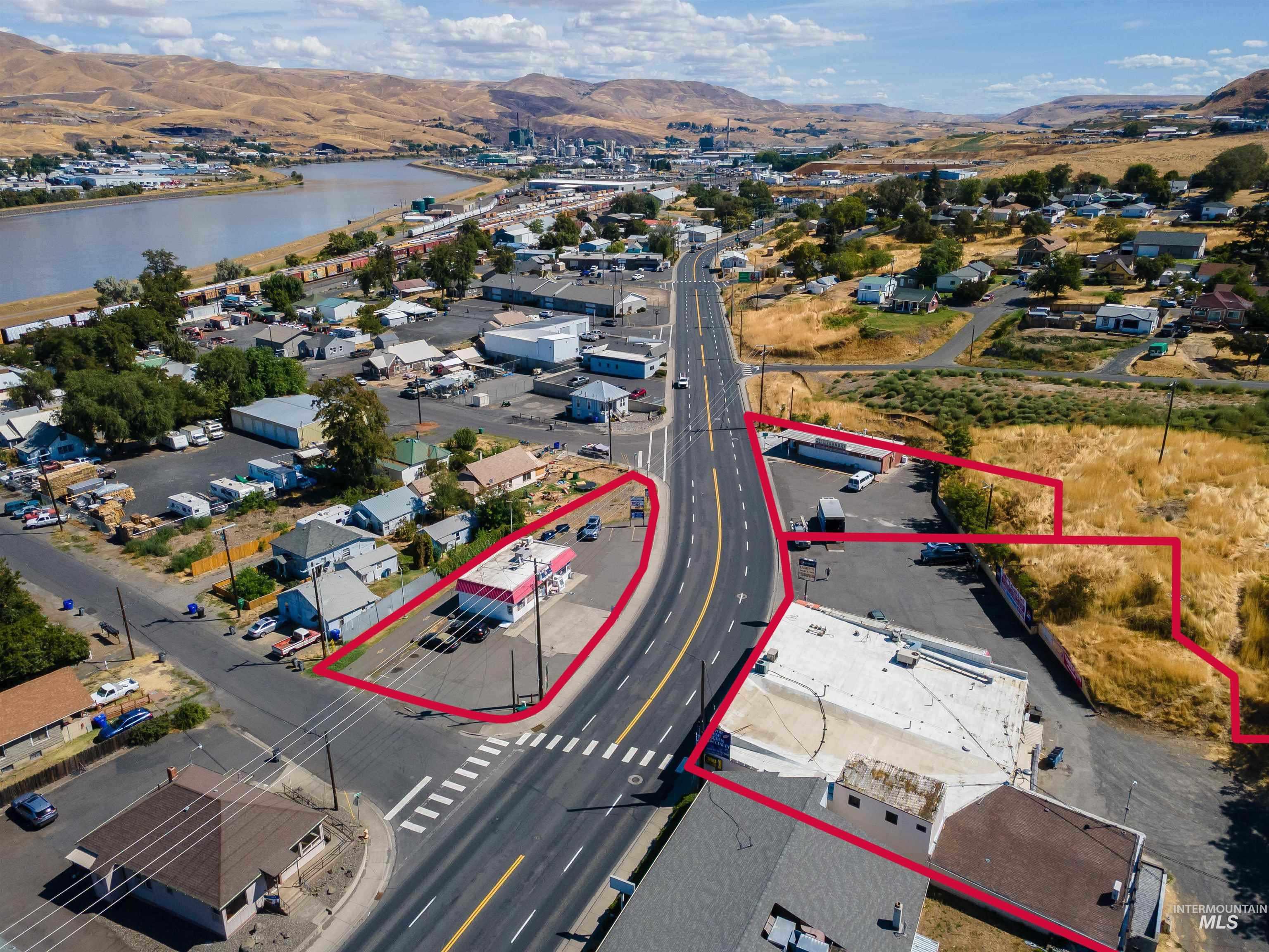 Aerial view of residential area with a water and mountain view and property parcel outlined