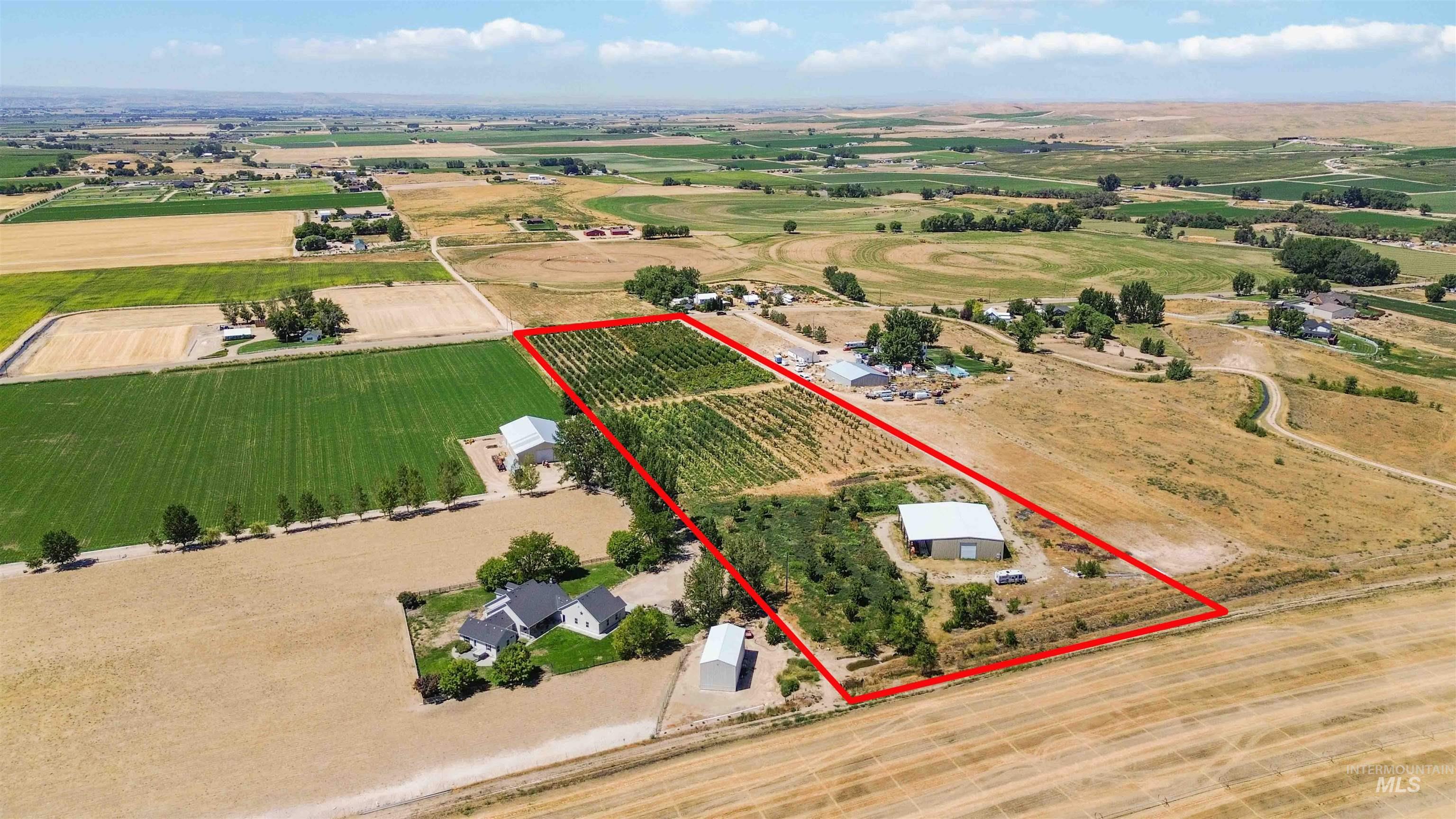 Aerial view of sparsely populated area featuring property boundaries highlighted and rows of crops