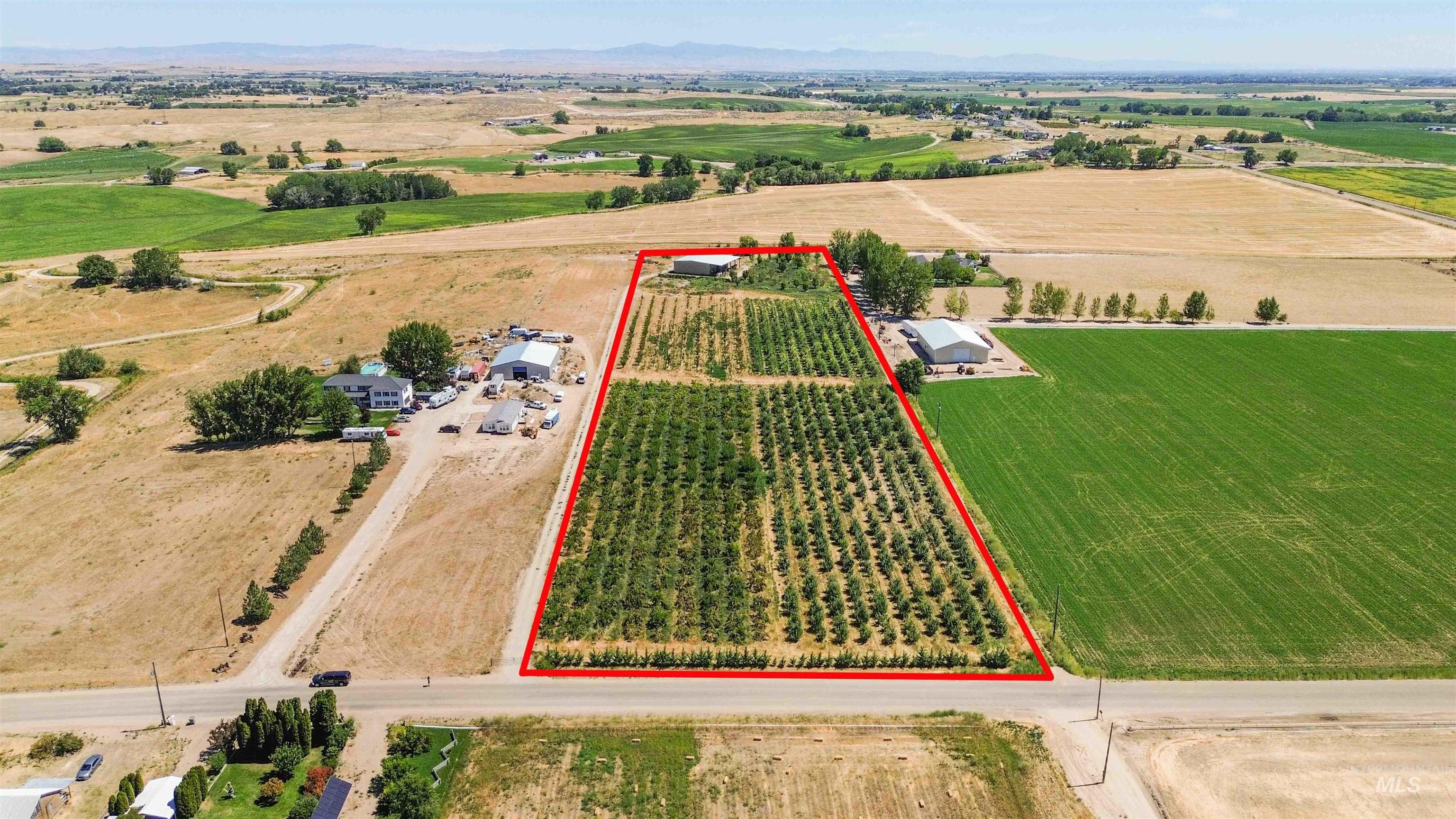 Overview of rural landscape with property parcel outlined and a mountain backdrop