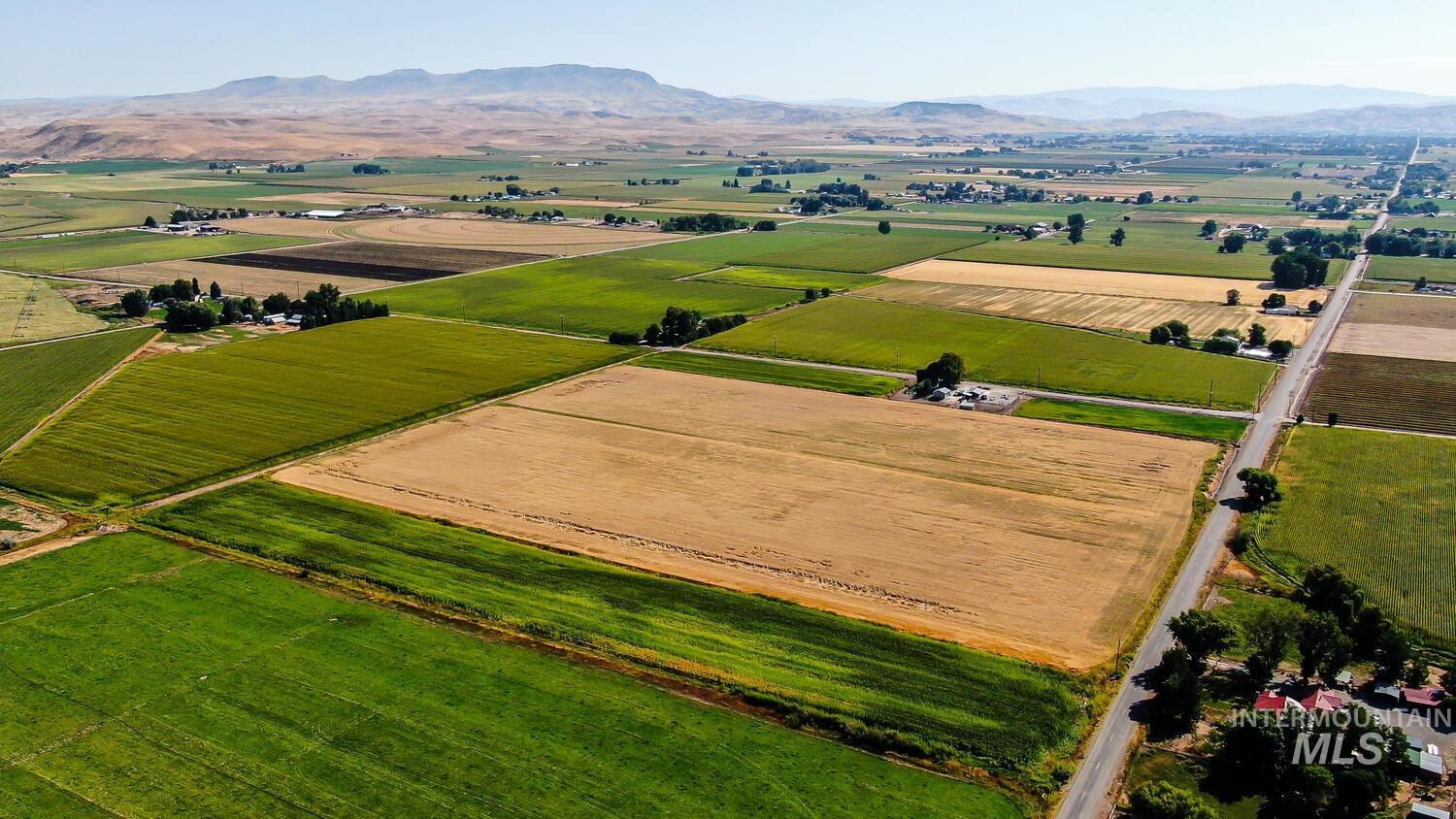 Aerial view of sparsely populated area with a mountain backdrop and farmland