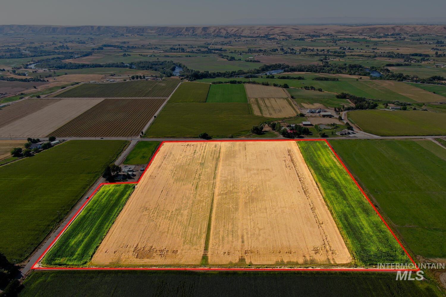 Overview of rural landscape featuring property parcel outlined and large plots for crops