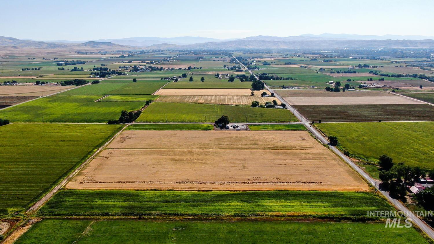 Overview of rural landscape featuring extensive farmland and a mountainous background