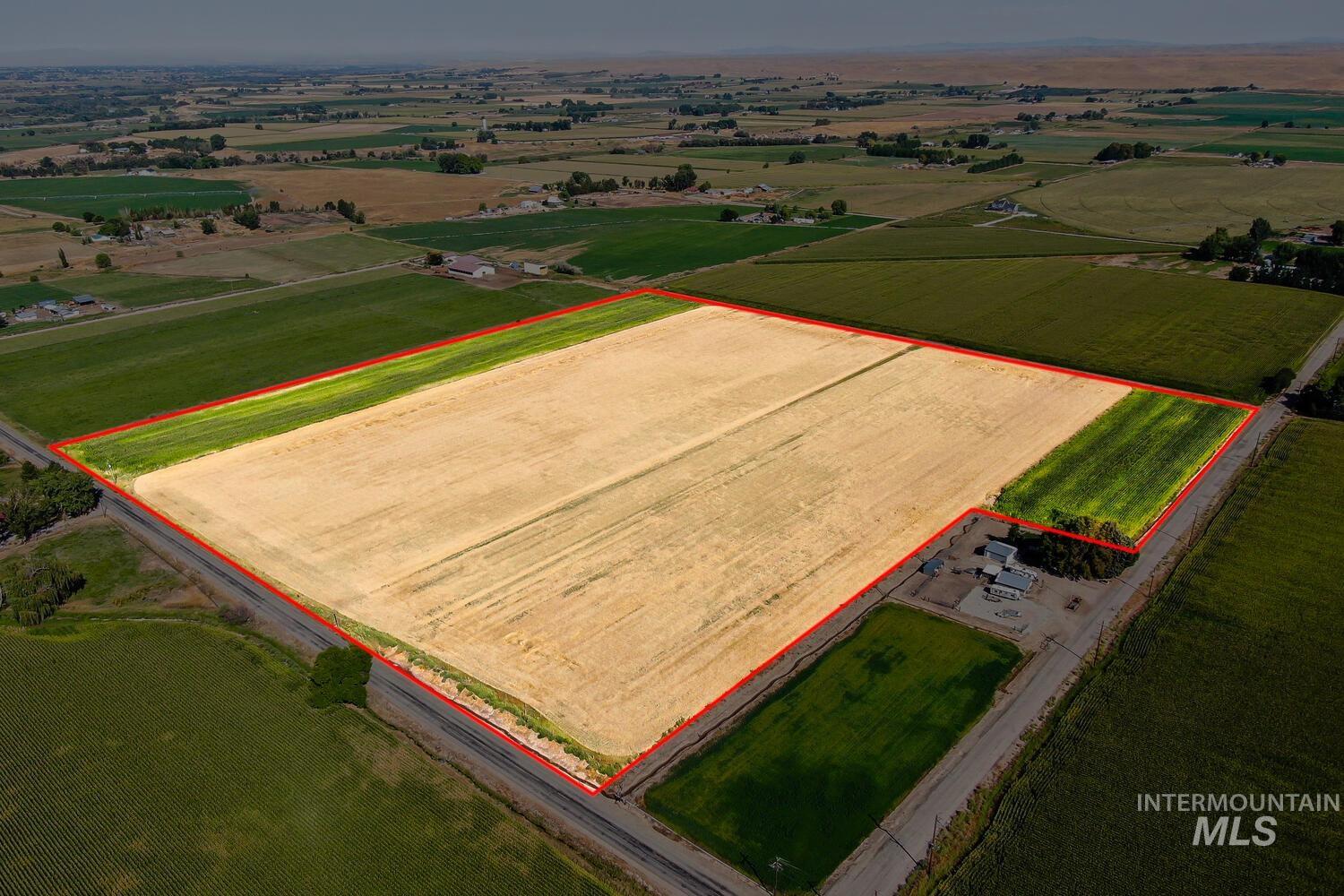 Aerial view of sparsely populated area with property parcel outlined and large plots for crops
