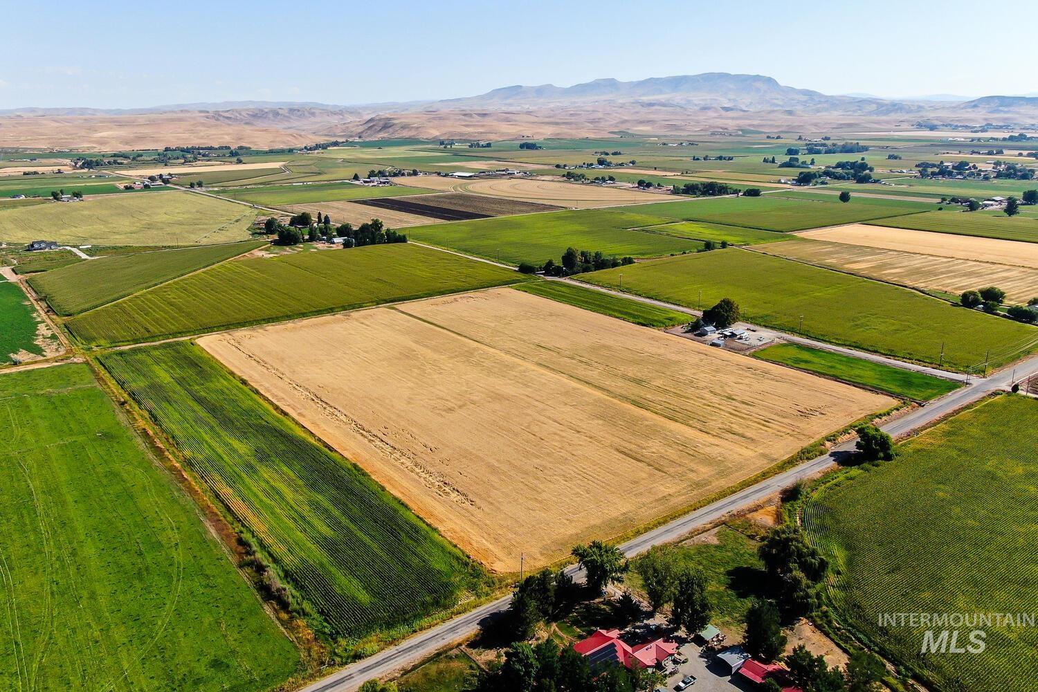 View of rural area with a mountain backdrop and large plots for crops